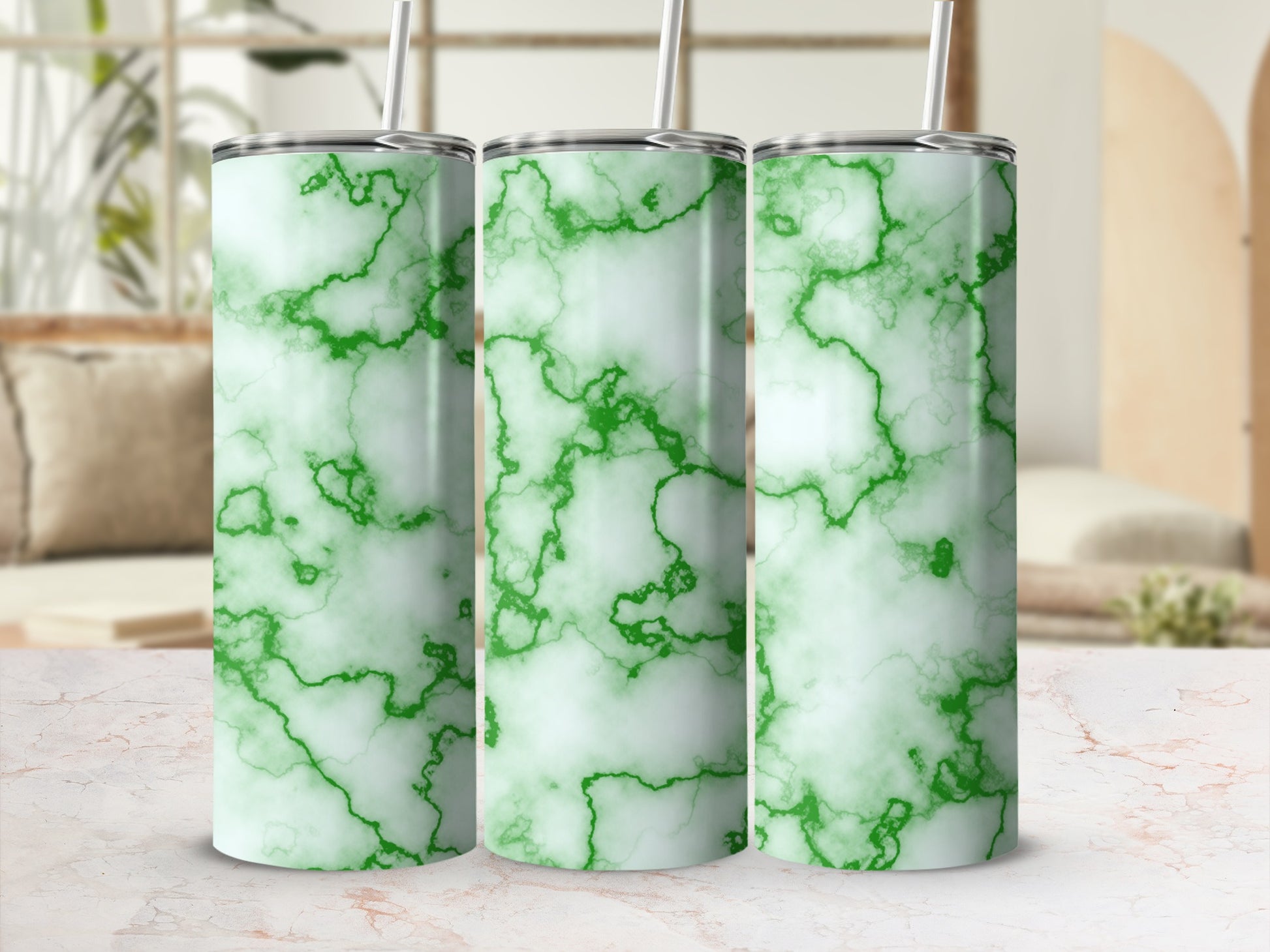 Three green marble pattern tumblers with straws on a white marble surface.