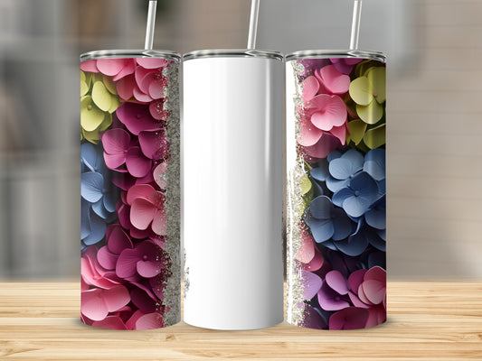 Three tumblers with floral designs and glitter accents on a wooden surface.