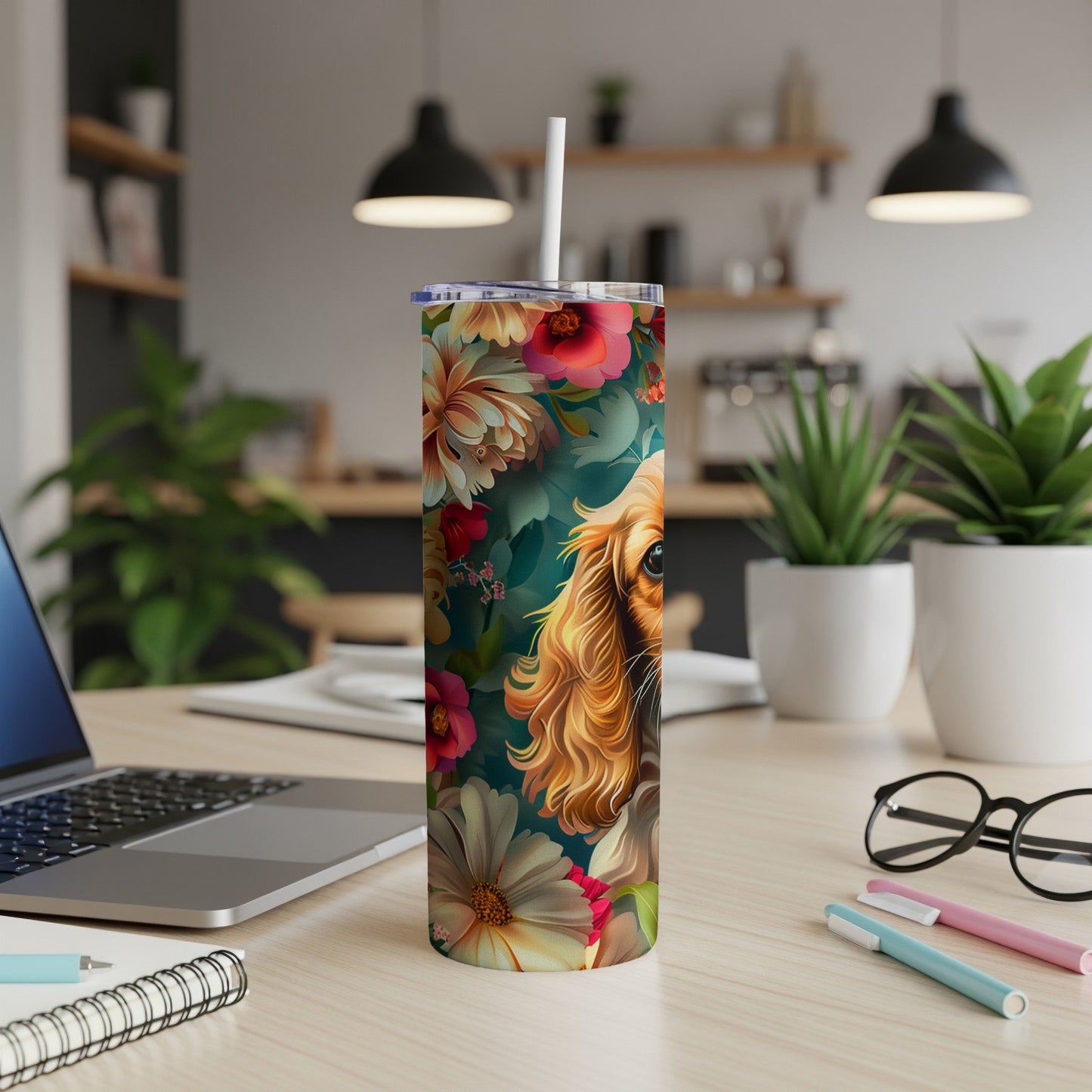 Floral tumbler featuring a dog's face and a straw on a desk.