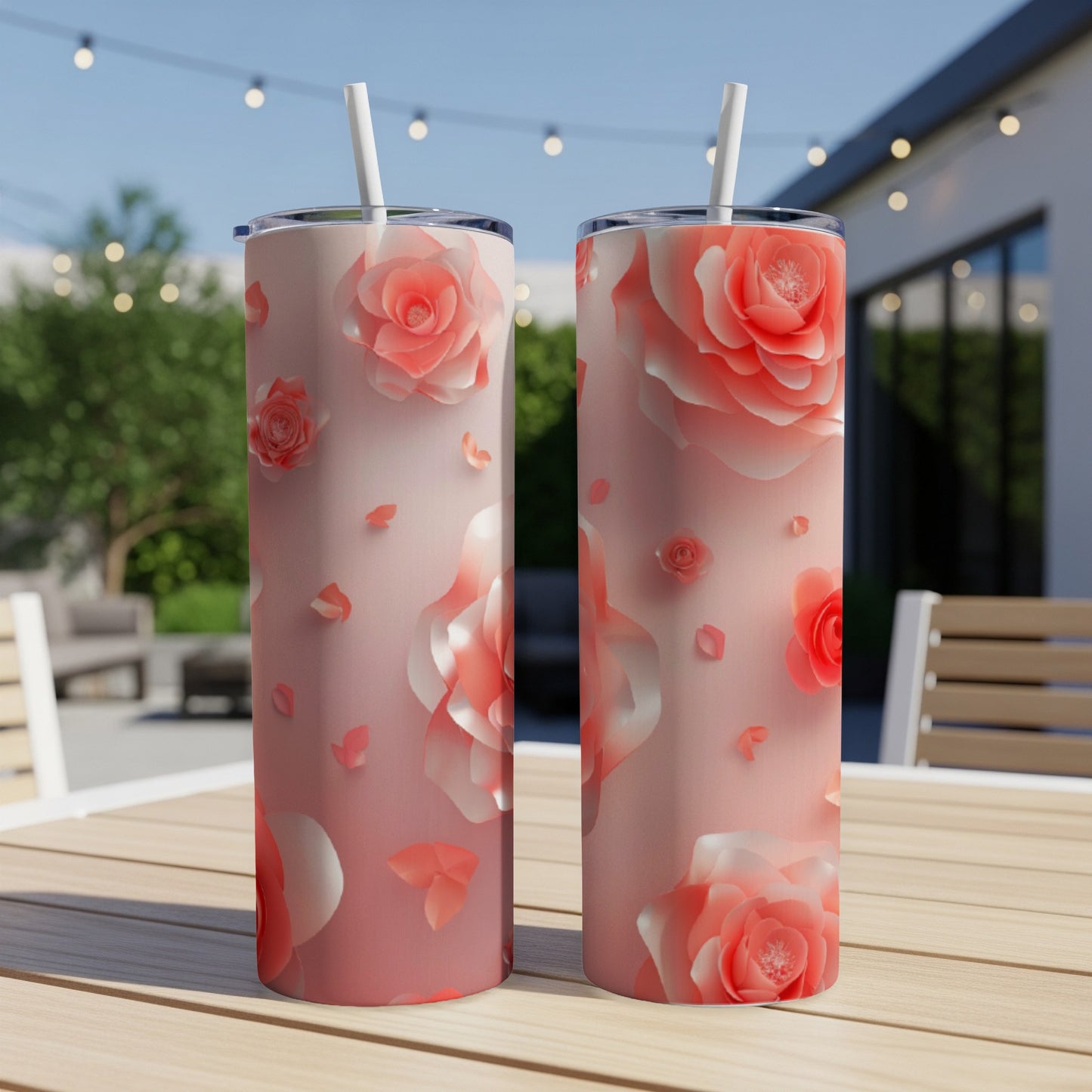 Two tall, slim tumblers with coral floral rose patterns on a wooden table.