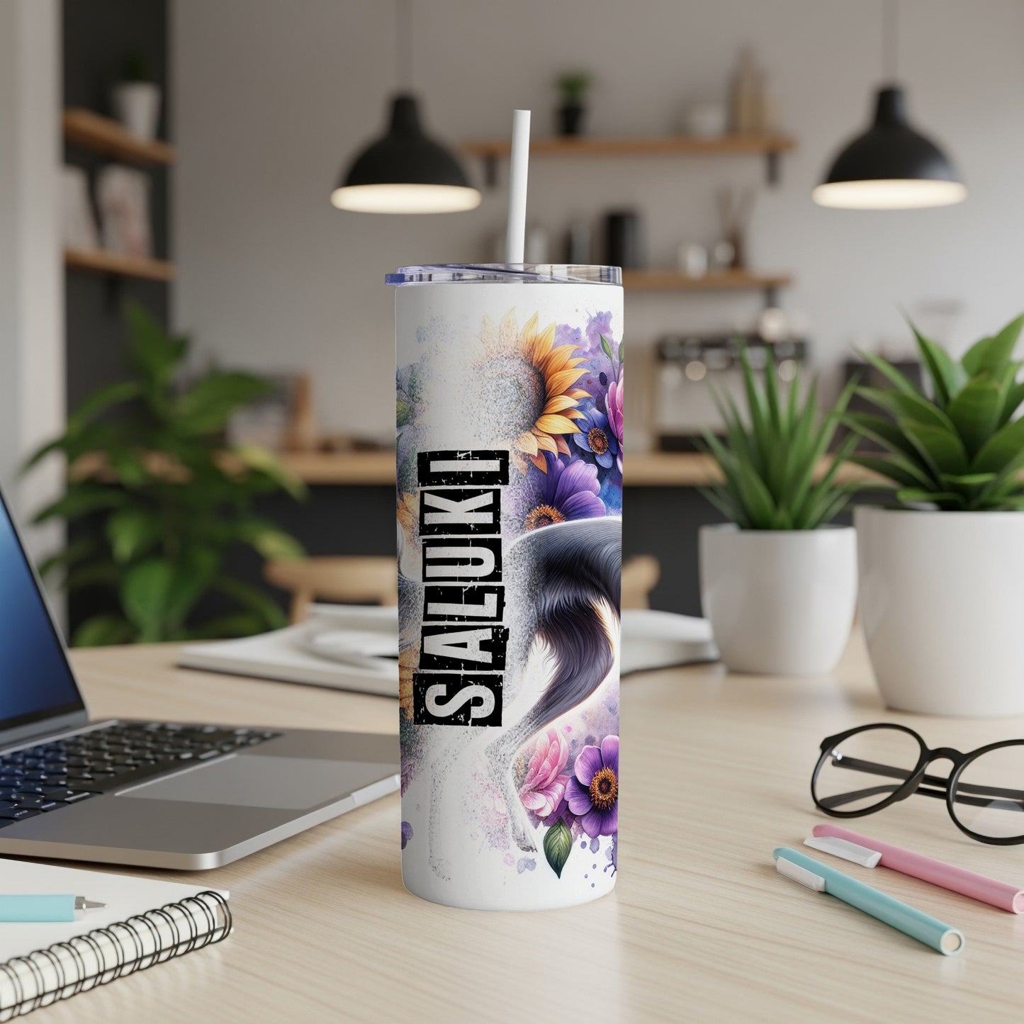 White tumbler with a dog and floral design, on a desk.