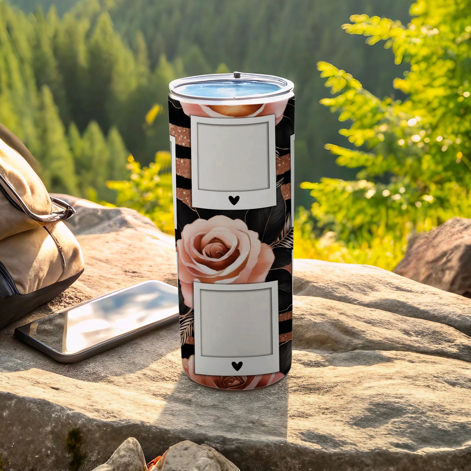 Tumbler with rose and leaf design and two photo frames, outdoors.