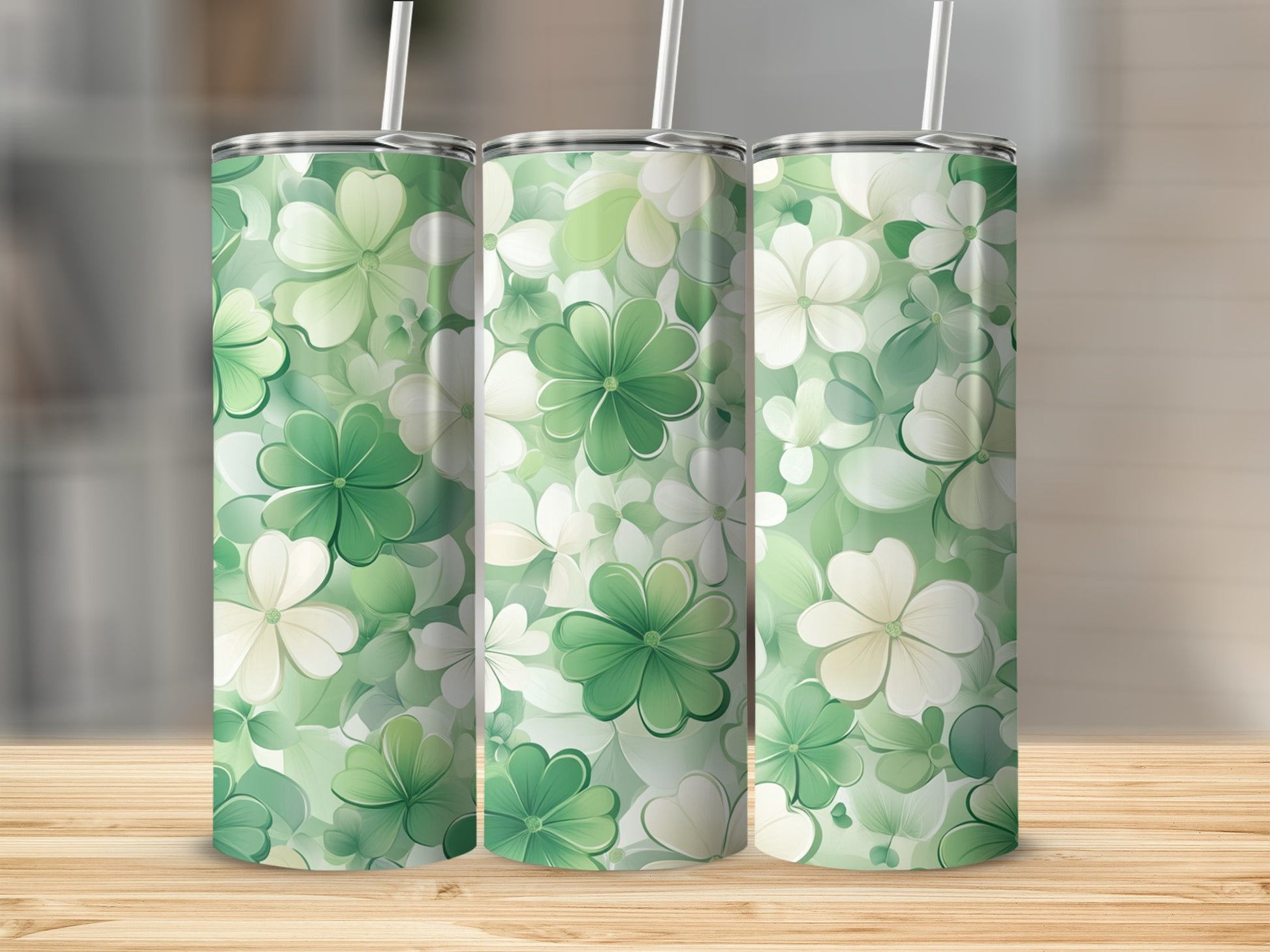 Three green and white shamrock pattern tumblers on a wooden surface.