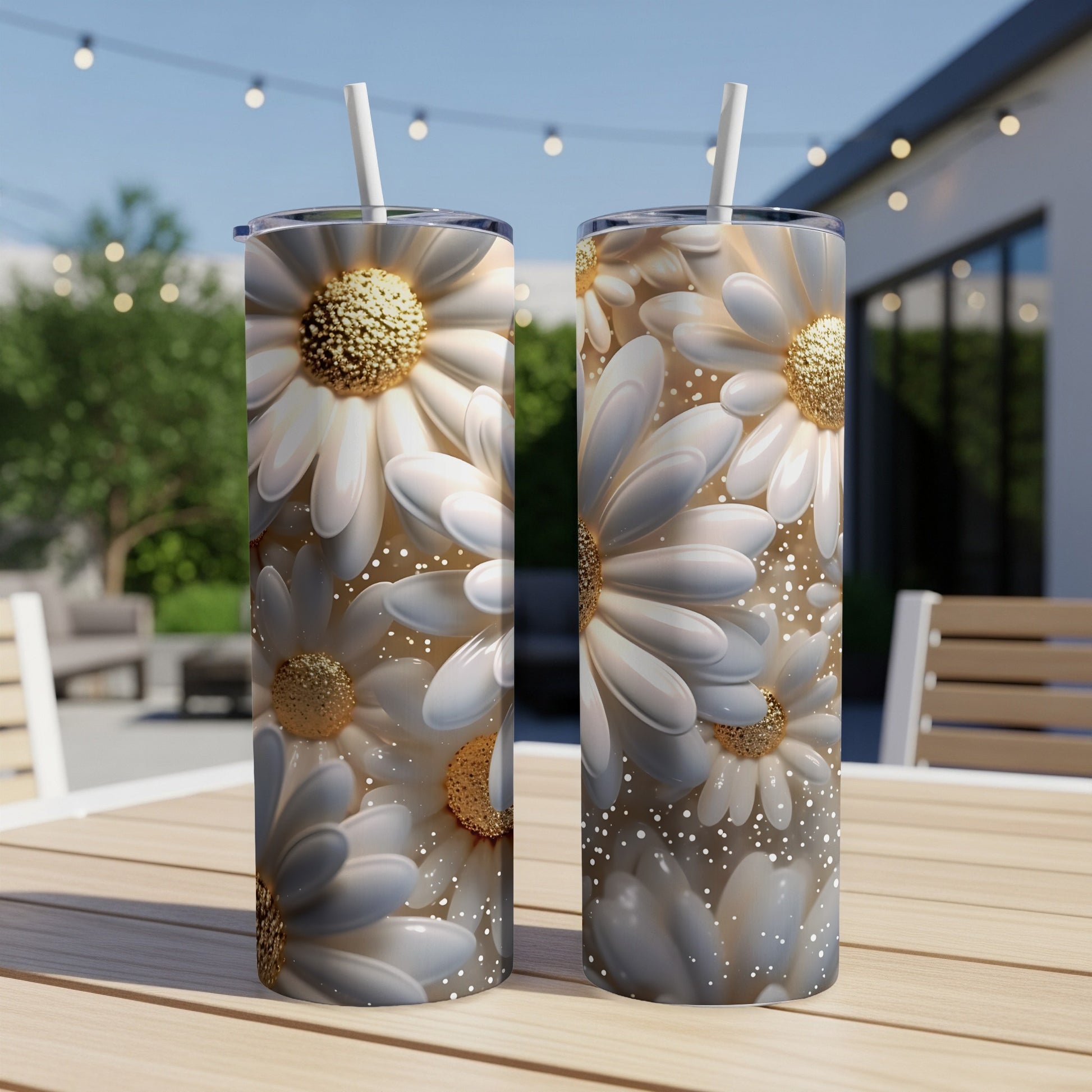 Two tall tumblers with white daisy floral design, straws inserted.