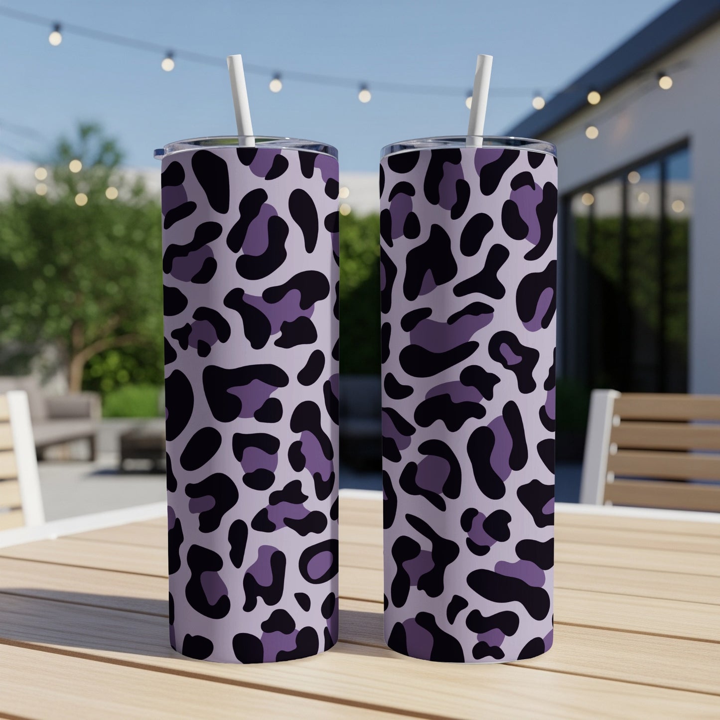 Two tumblers with purple and black leopard print on a wooden table.