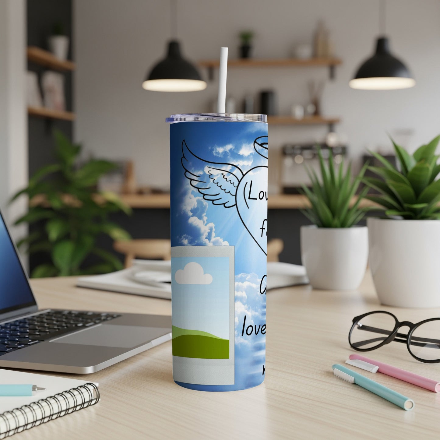 Tumbler with winged heart and text: "Love from above" on a blue sky background.