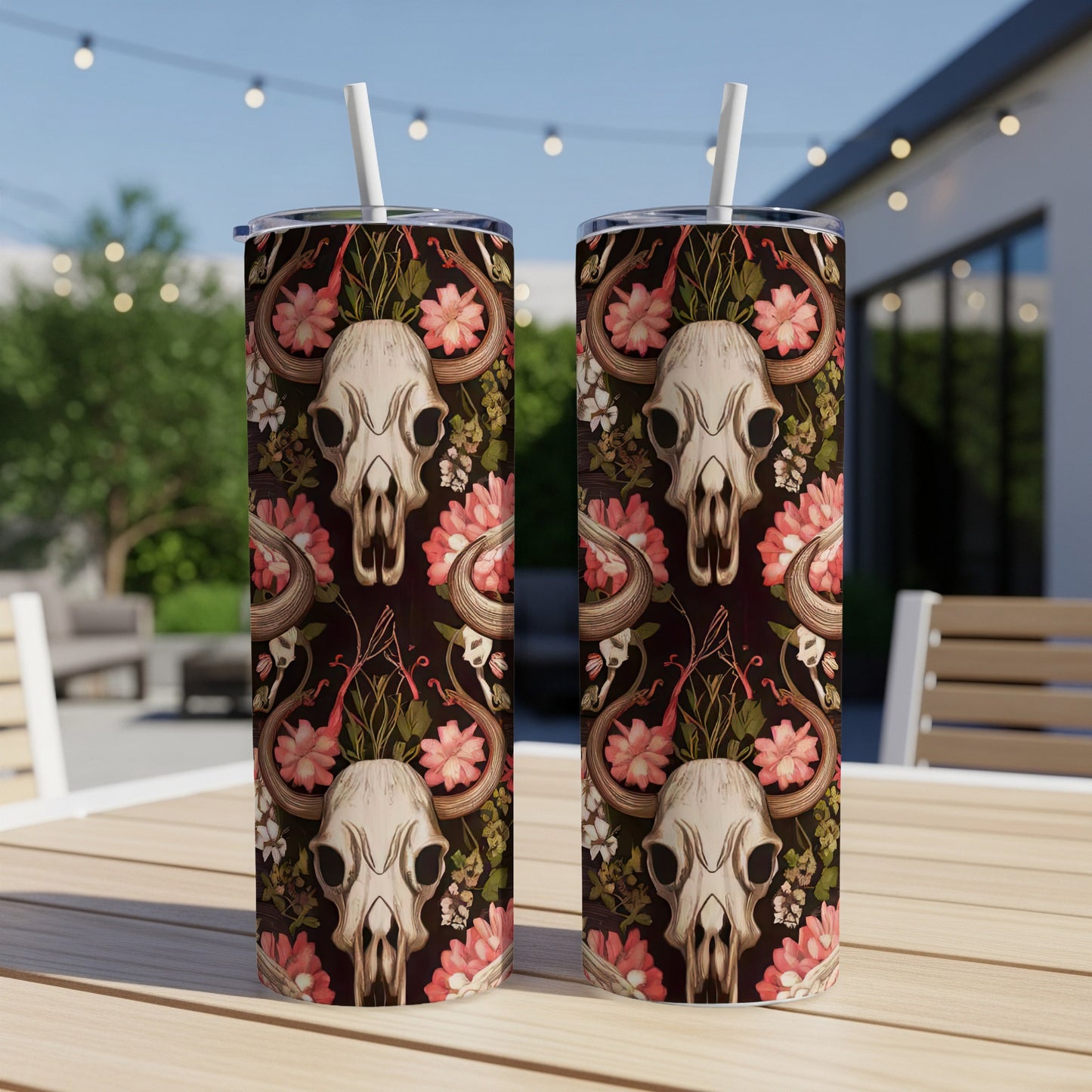 Two tumblers with skull, floral, and snake pattern on an outdoor table.