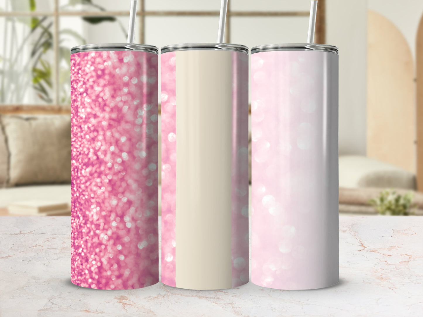 Three glitter tumblers in pink and cream with straws.
