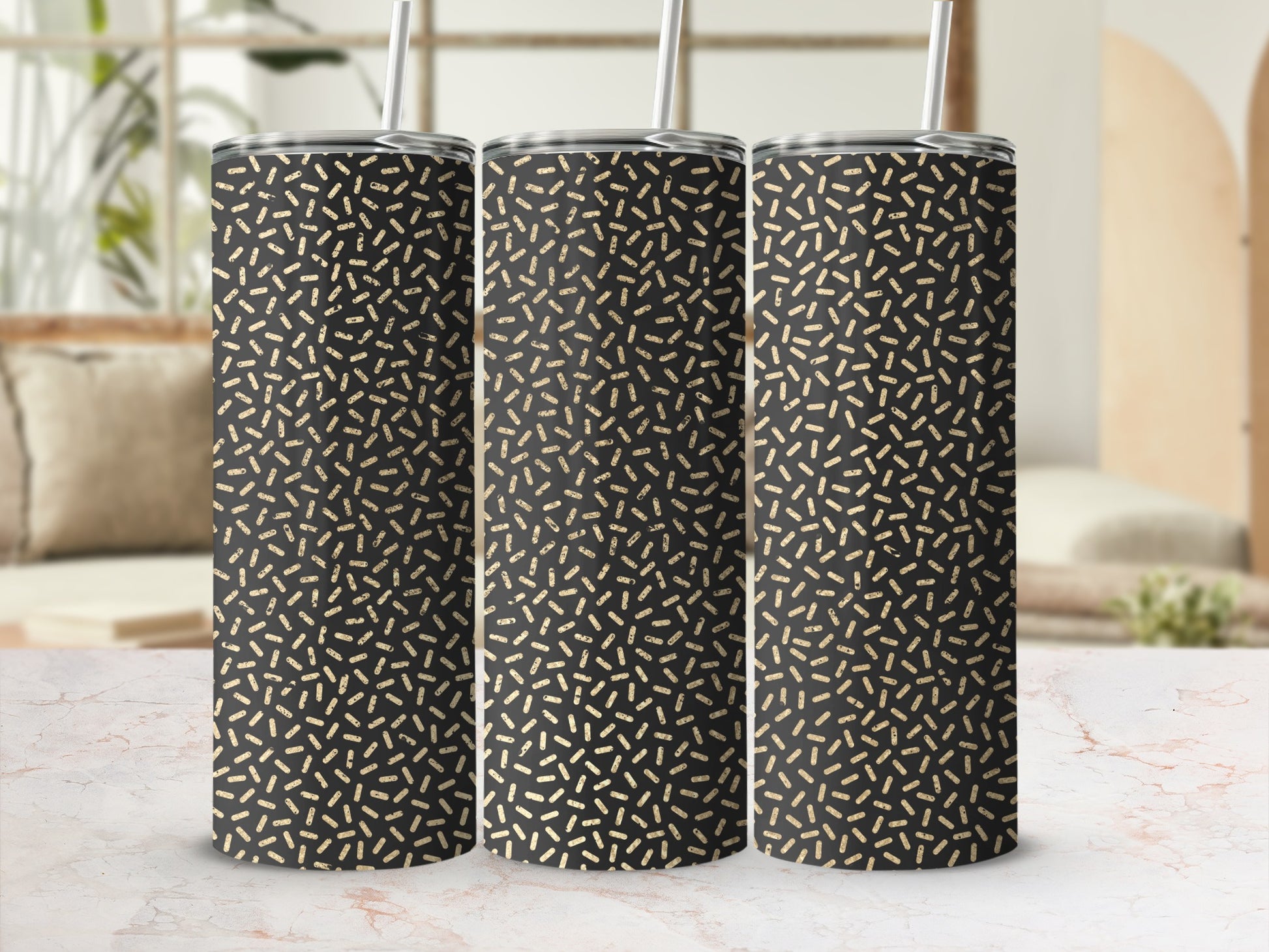 Three black tumblers with a gold dashed pattern and silver straws.