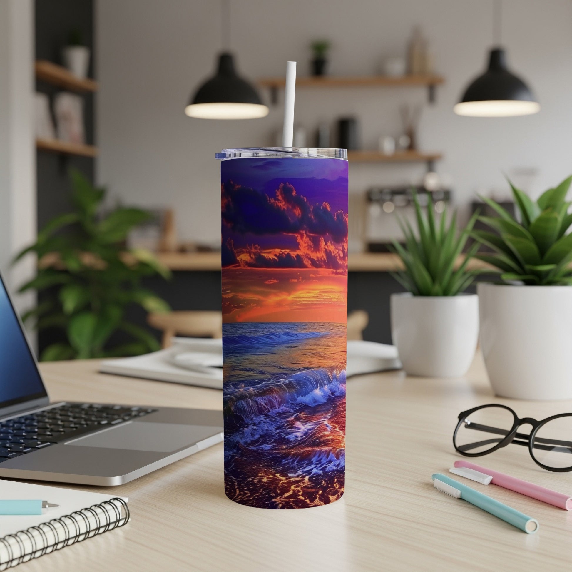 Sunset ocean waves design on a white tumbler with straw, on a desk.