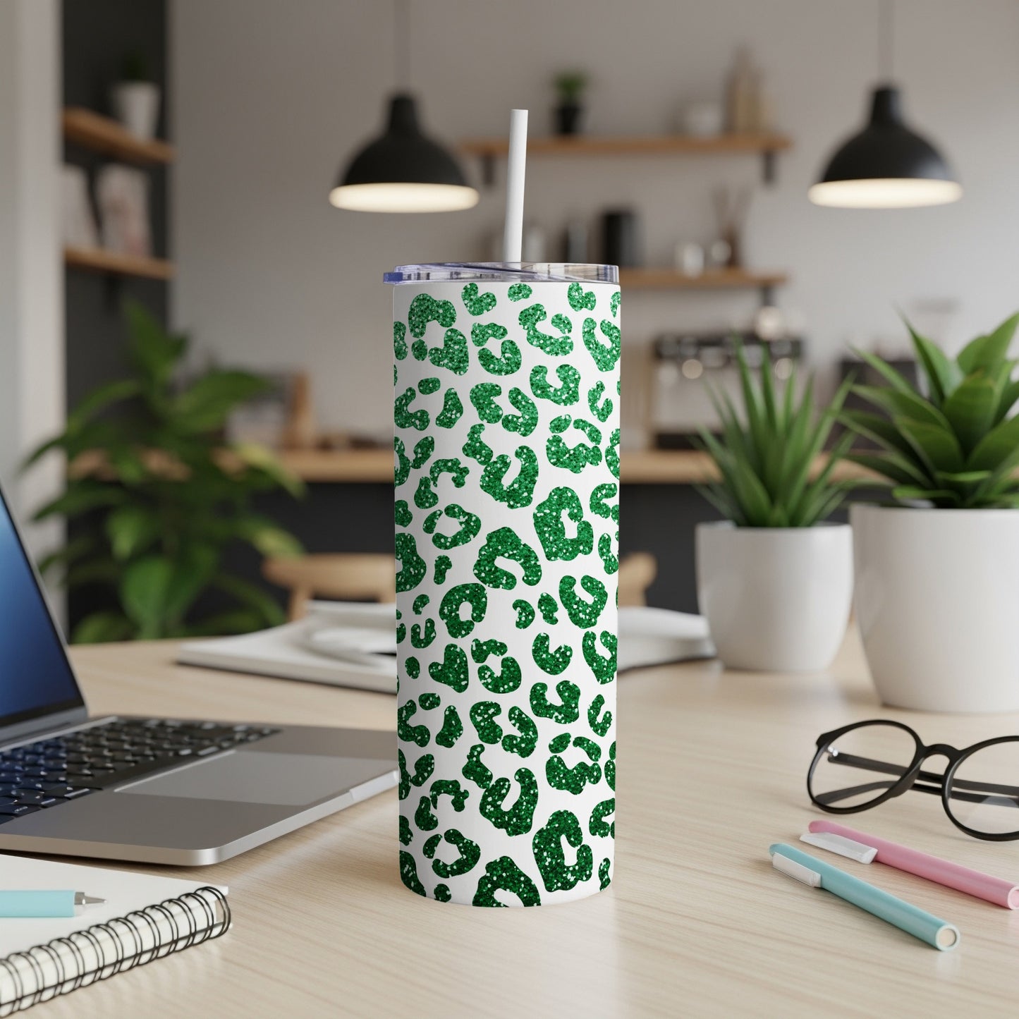 Green leopard print skinny tumbler with straw on a desk.
