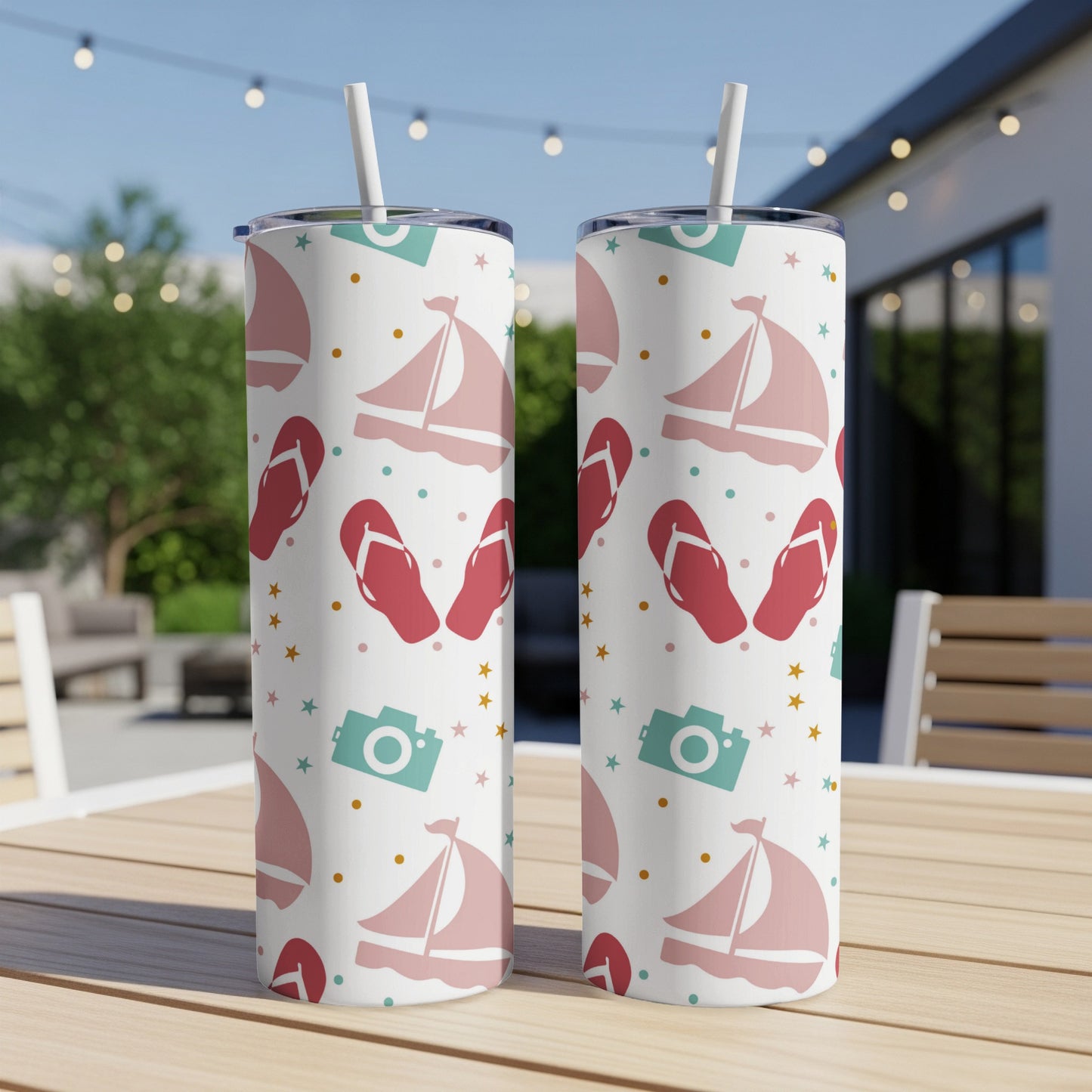 Two pink and white sailboats, flip-flops, and cameras on a white tumbler.