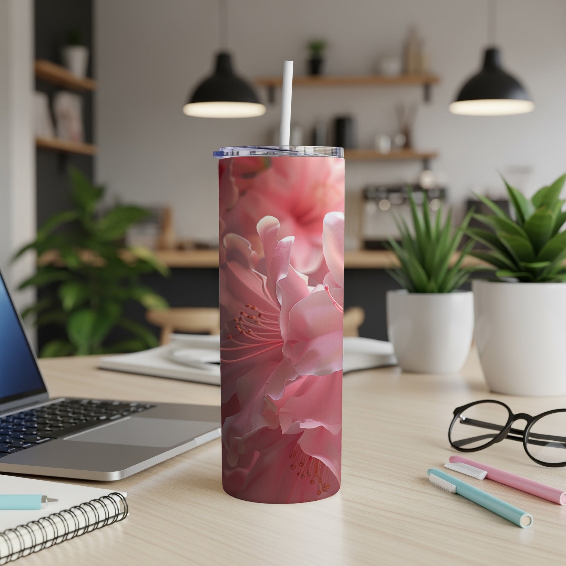 Close-up of pink azalea flowers on a white skinny tumbler with straw.