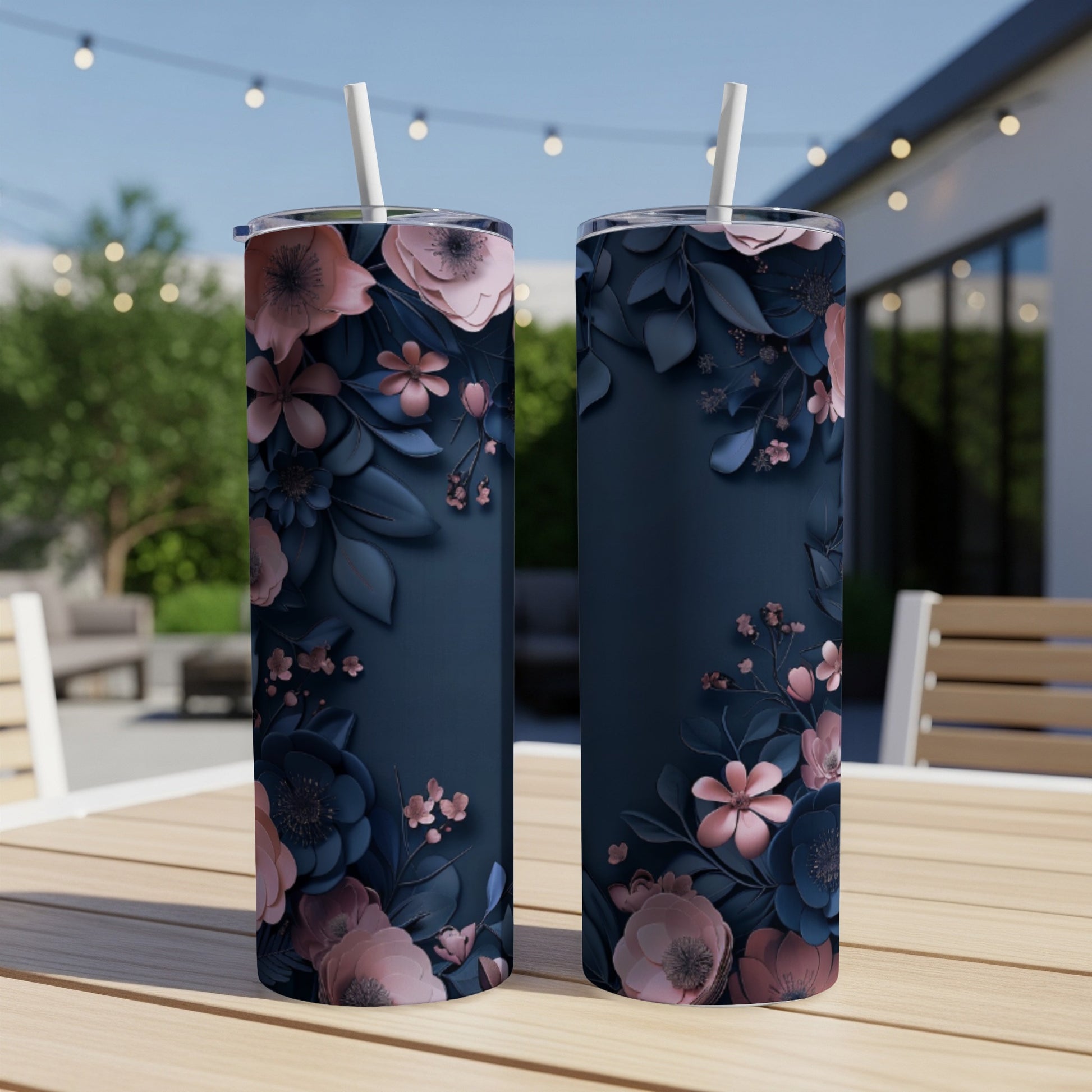 Two navy blue tumblers with pink and blue floral patterns sit on a table.