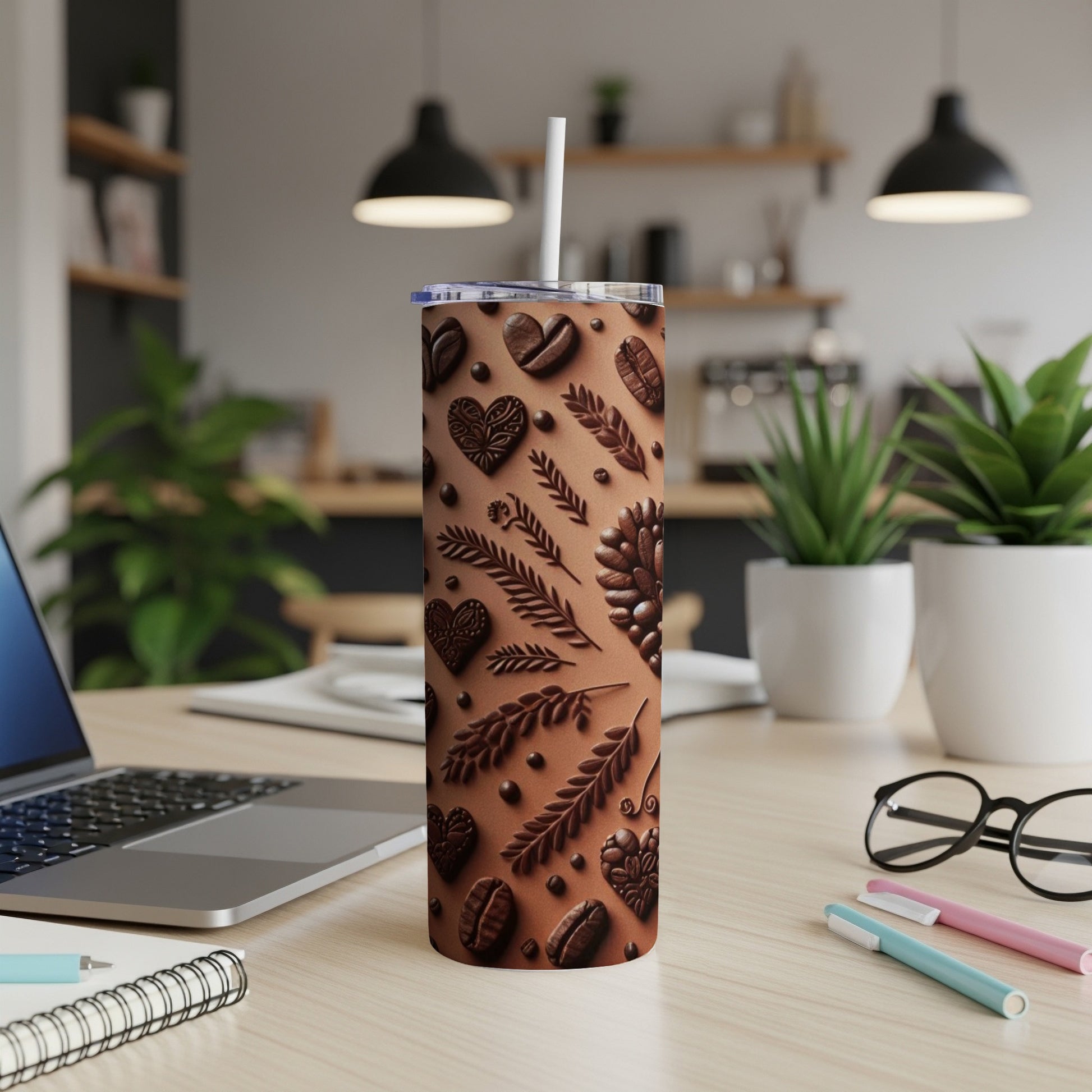 Brown tumbler with embossed coffee beans and leaves, with a straw.