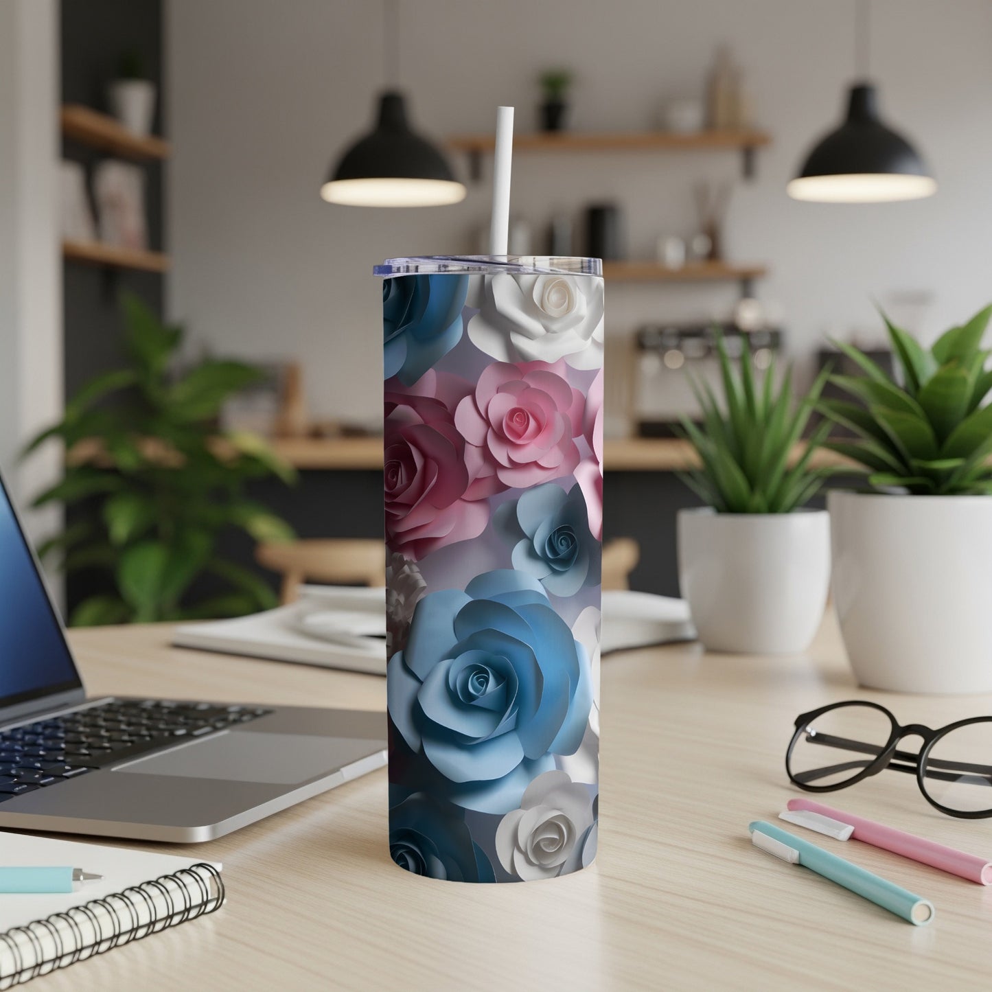 White, pink, and blue floral pattern tumbler on a desk with a laptop and pens.