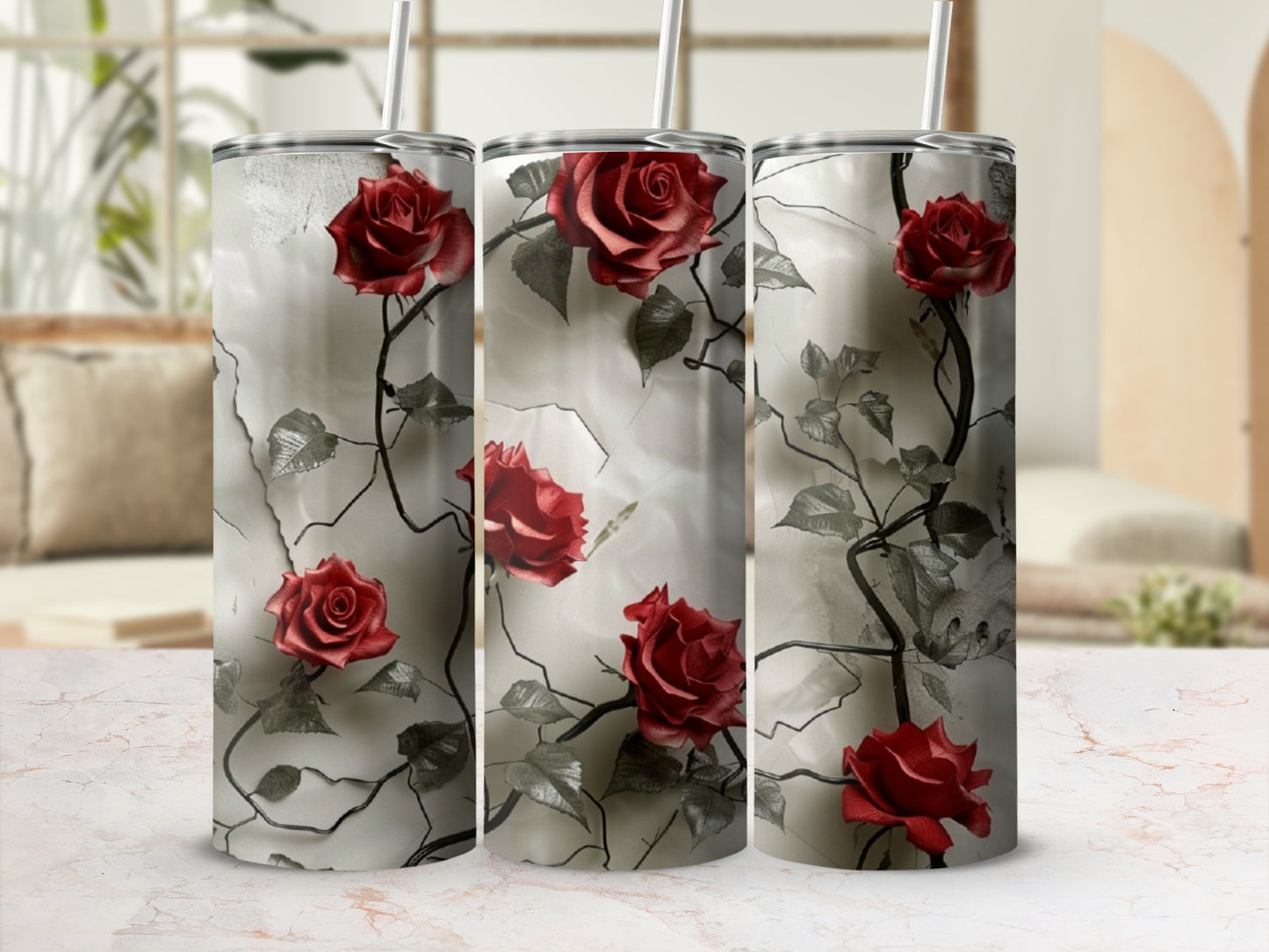 Three tumblers adorned with red roses and dark vines against a marbled background.