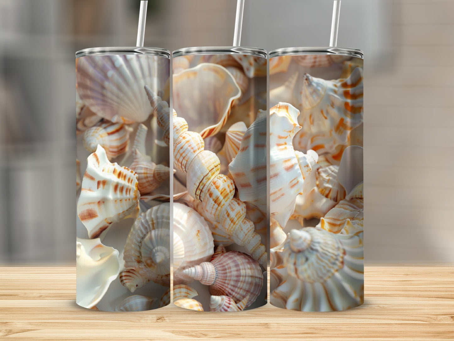 Three tumblers with seashell designs on a wooden surface.