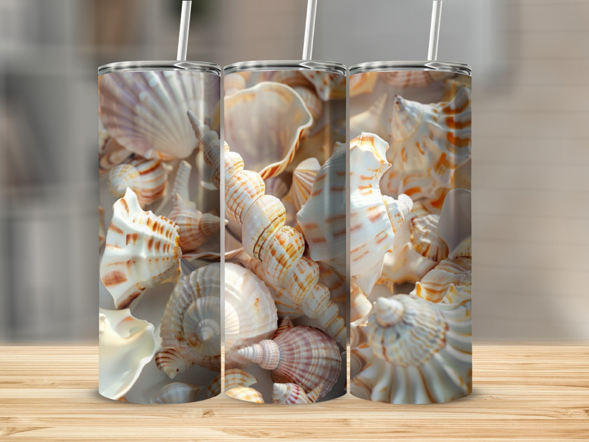 Three tumblers with seashell designs on a wooden surface.
