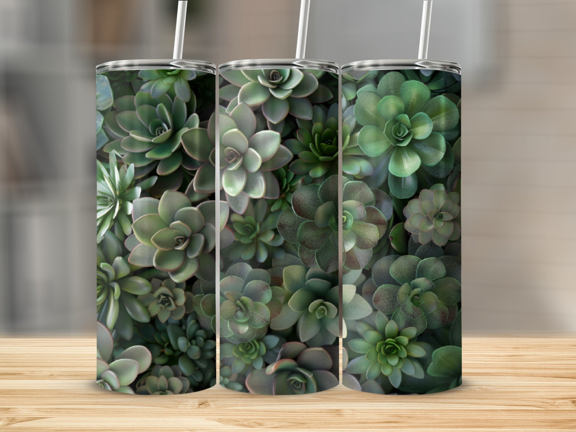 Three tumblers with a repeating pattern of green succulents on a wooden surface.