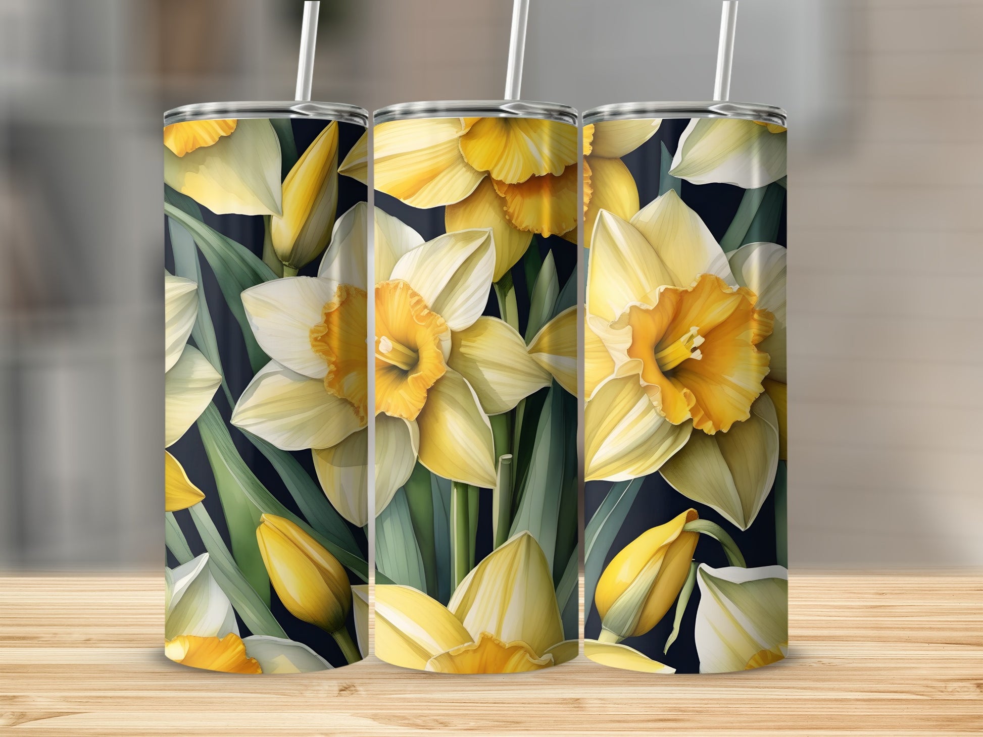 Three tumblers with a repeating daffodil floral pattern on a wooden surface.