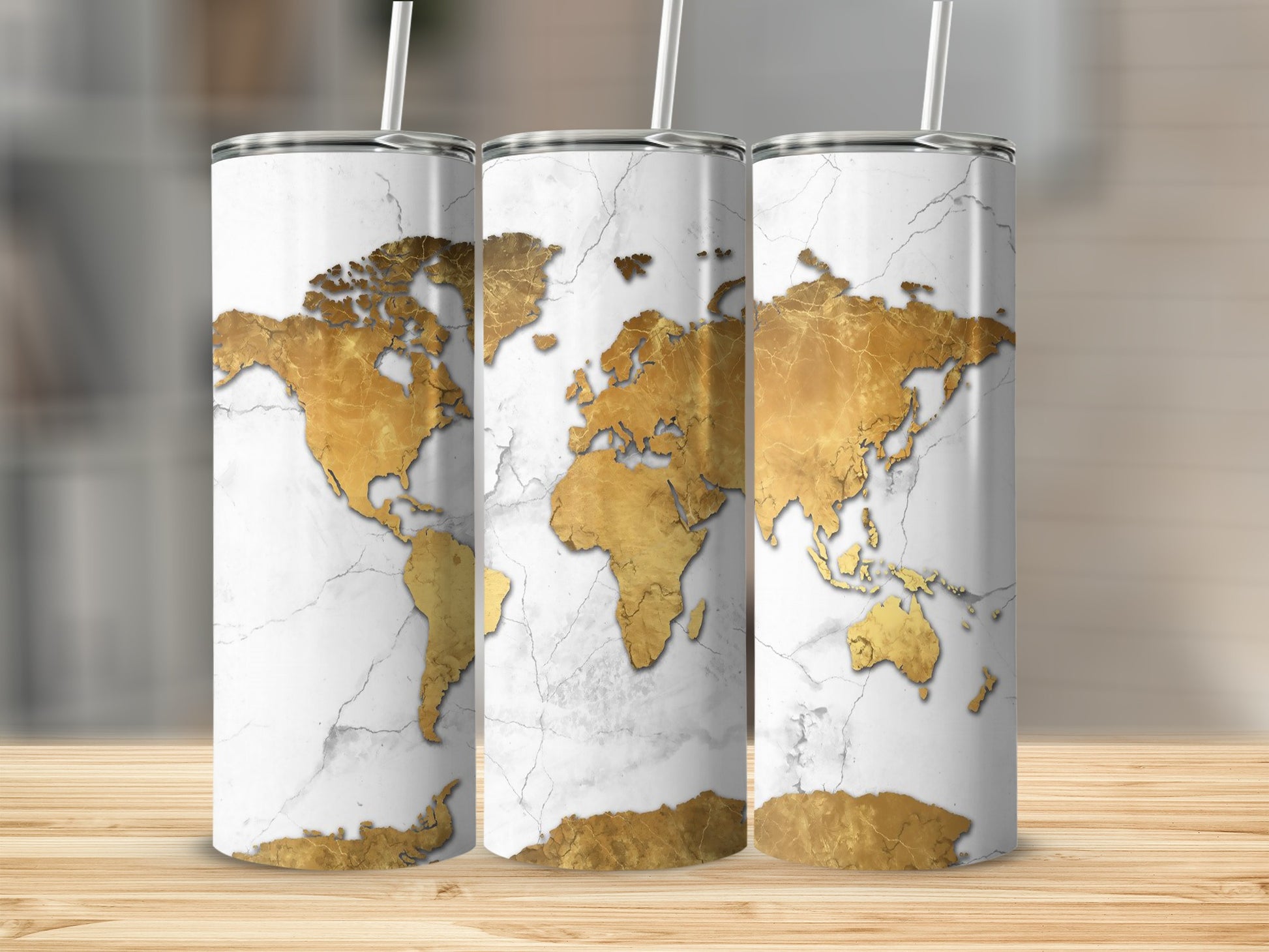 Three tumblers with a white marble background and gold world map design.