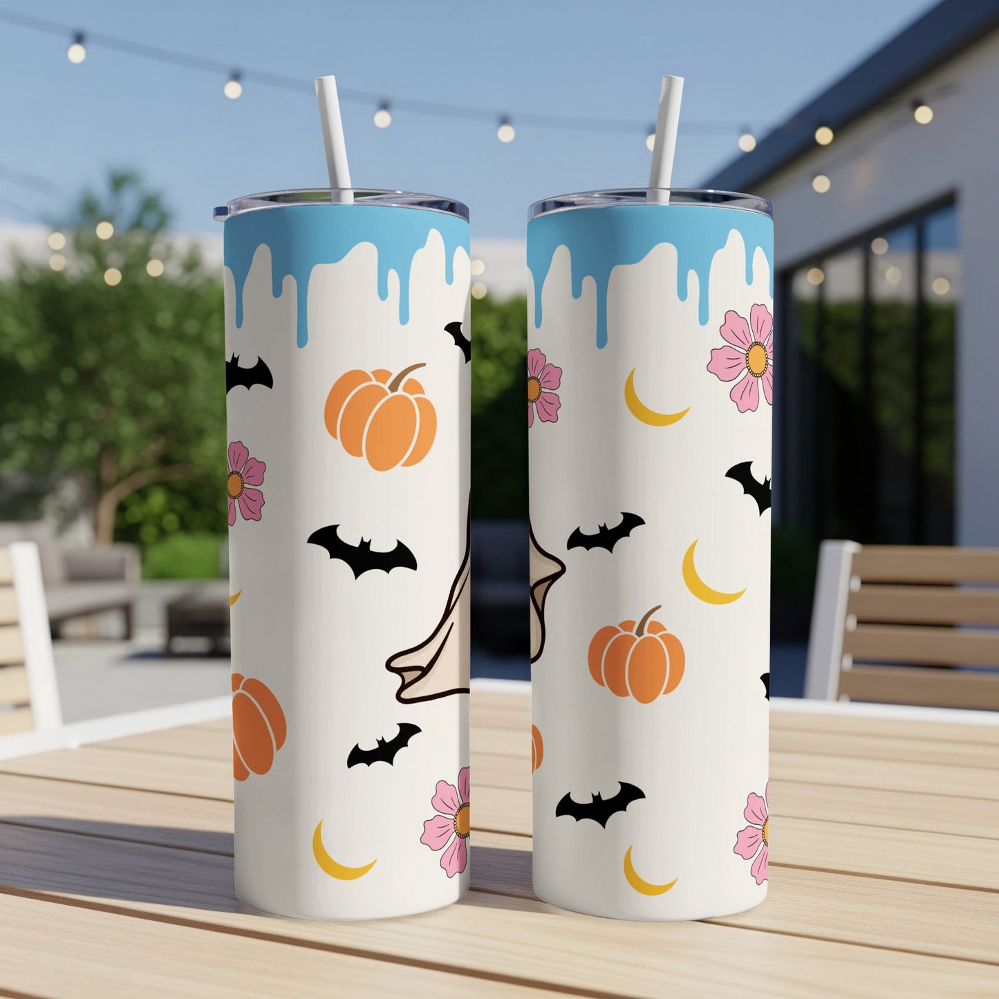 Two tumblers with Halloween icons and blue drips against an outdoor background.