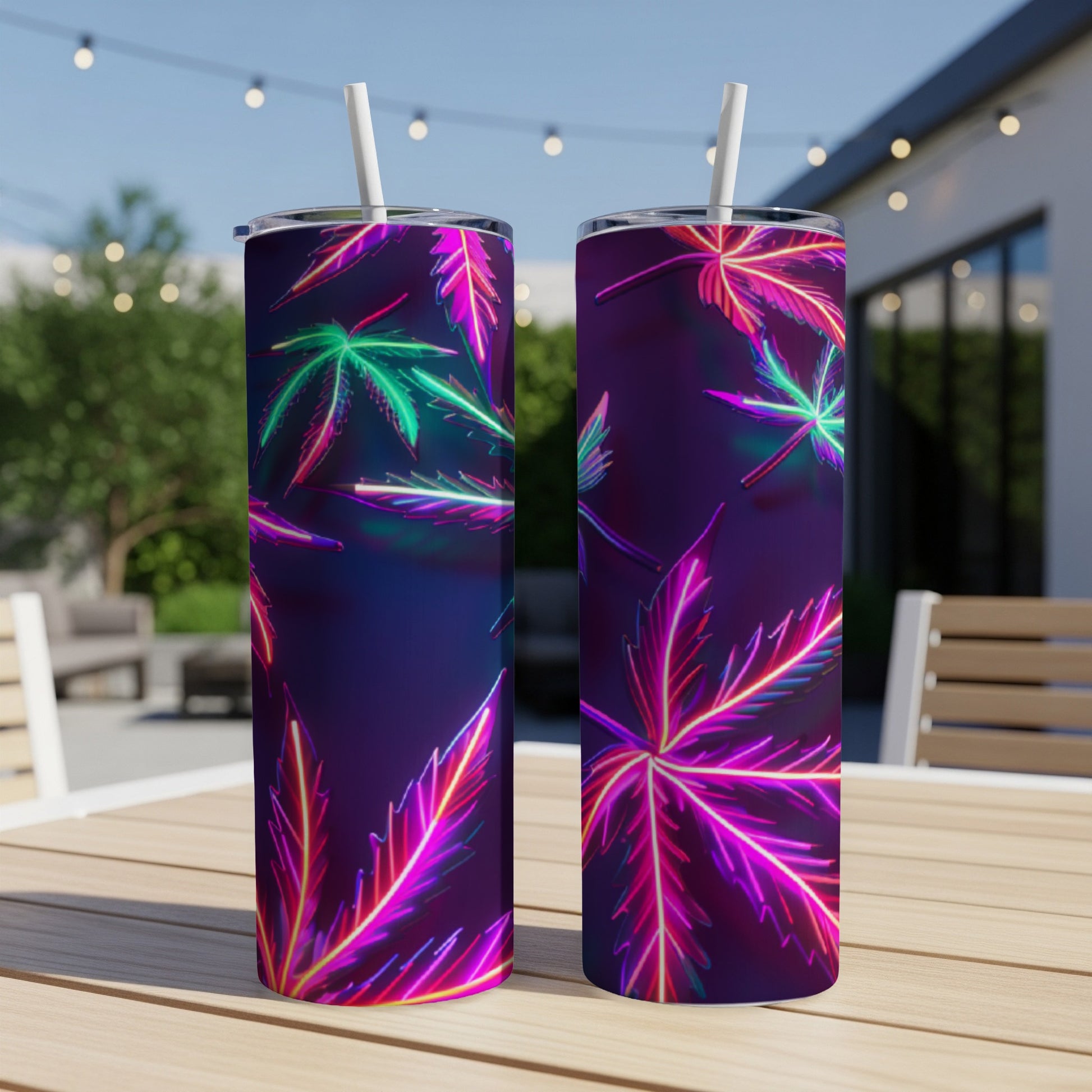 Two tumblers with neon cannabis leaf design on an outdoor table.