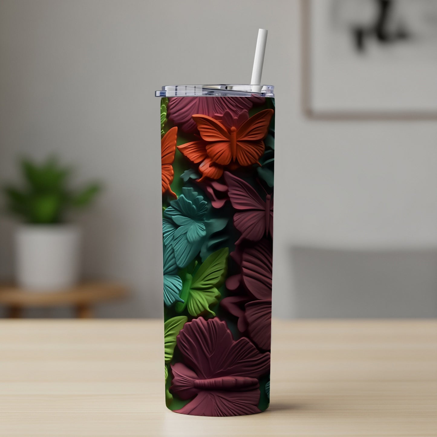 Tall tumbler with embossed colorful butterflies and a white straw.