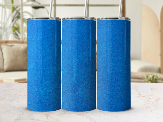 Three sparkly blue tumblers with straws on a marble surface.