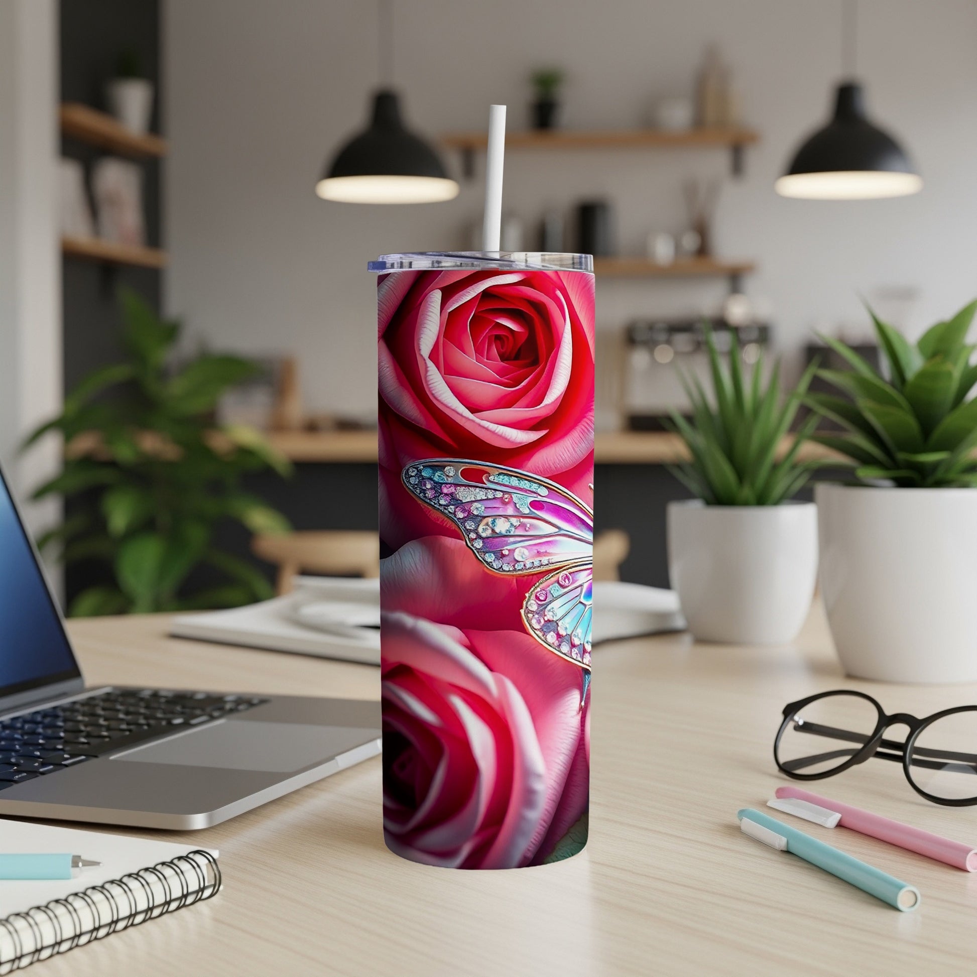 Tumbler with pink roses and a jeweled butterfly design, a straw inserted.