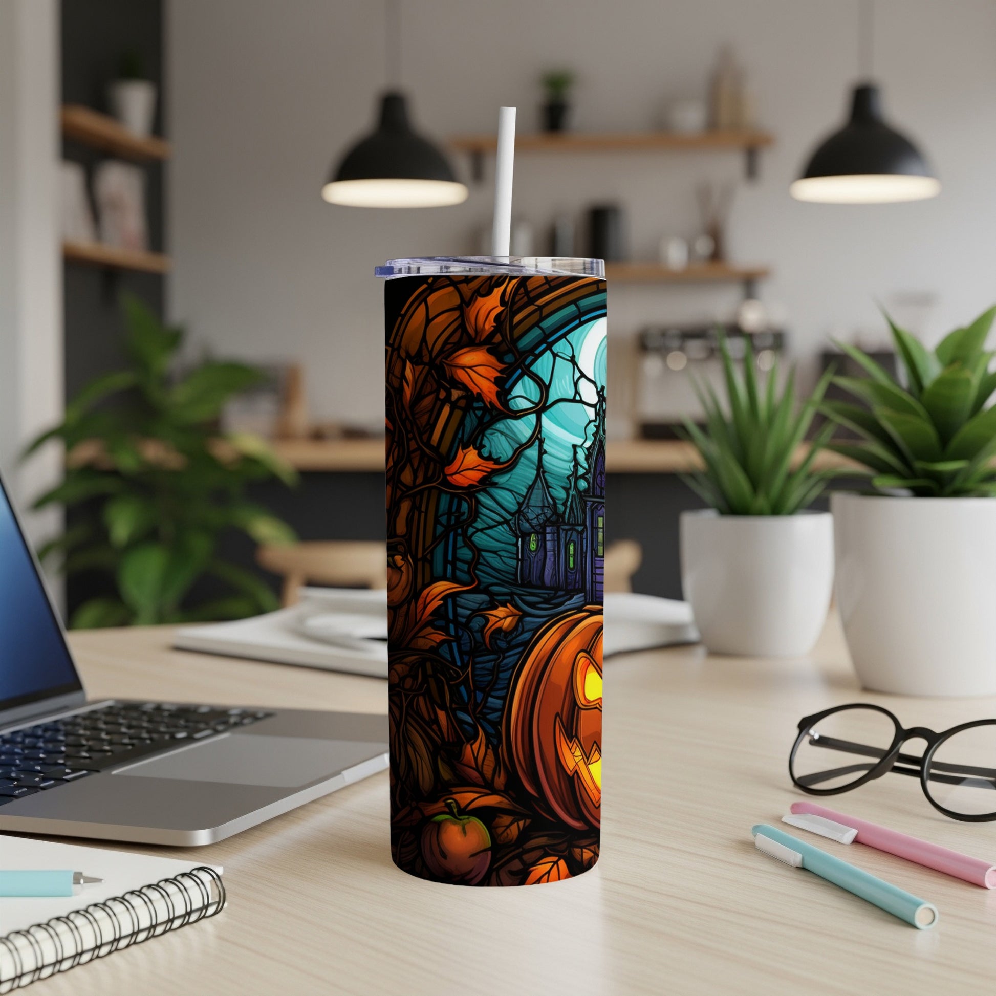 Halloween tumbler with jack-o'-lantern and spooky house design.