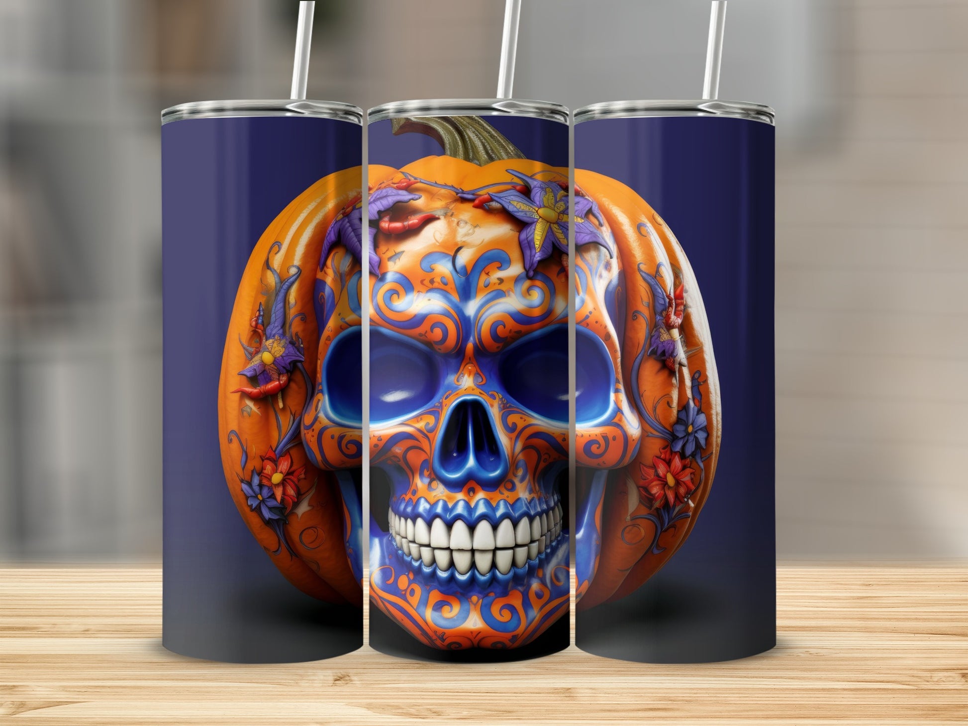 Three tumblers featuring a pumpkin skull design with orange and blue swirls and floral accents.