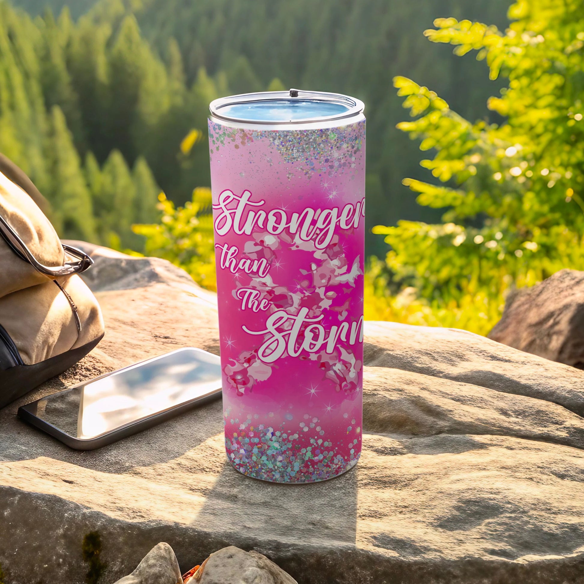 Pink tumbler with "Stronger than the Storm" text and glitter accents.