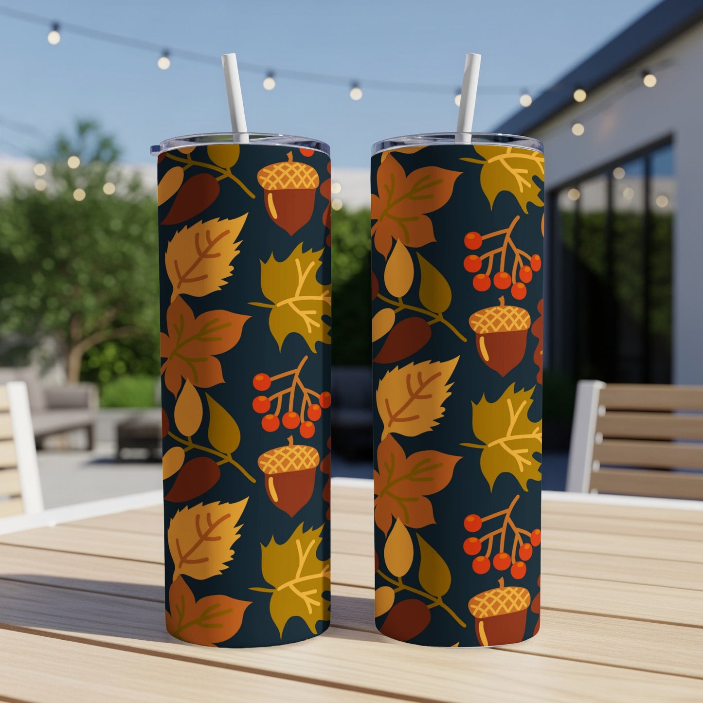 Two tumblers with autumn leaves and acorn pattern on a table.