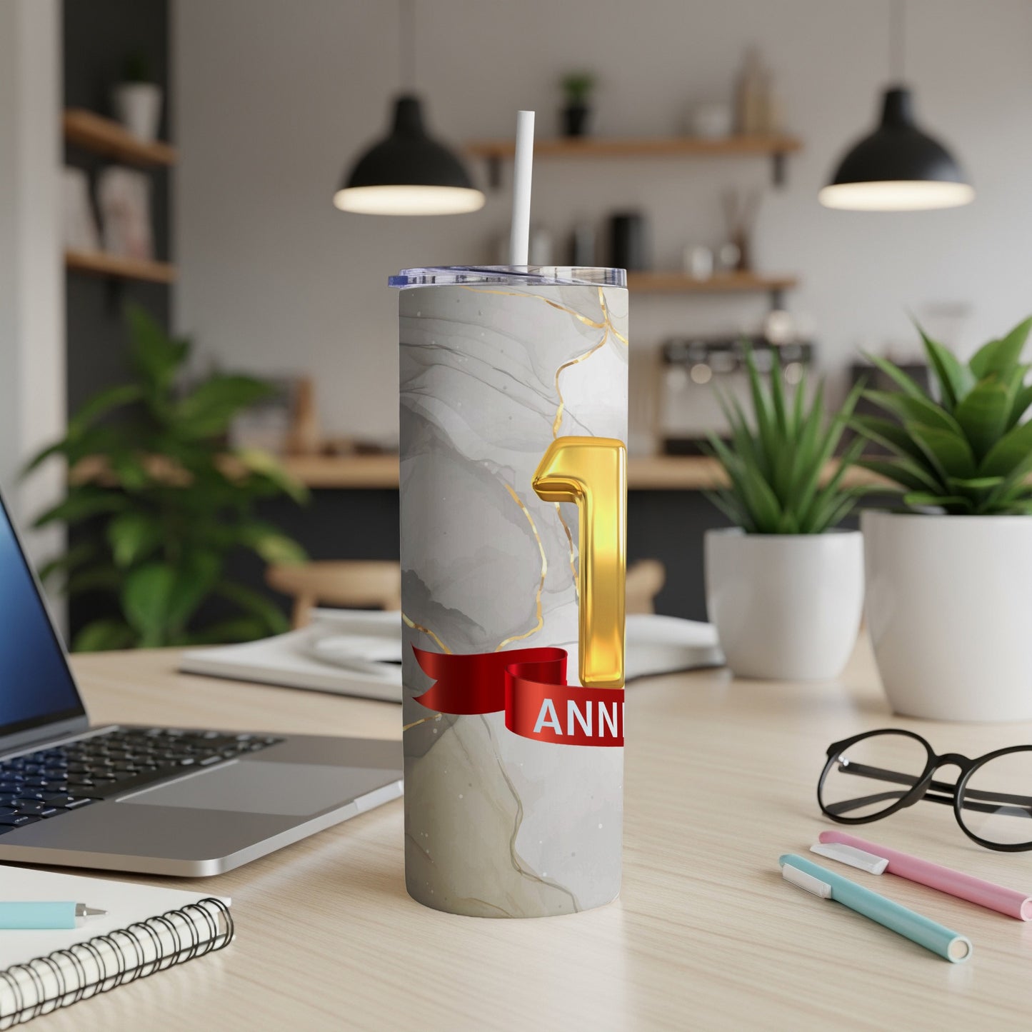 Gold "1" and "ANNIVERSARY" text on a marble-patterned tumbler with a straw.