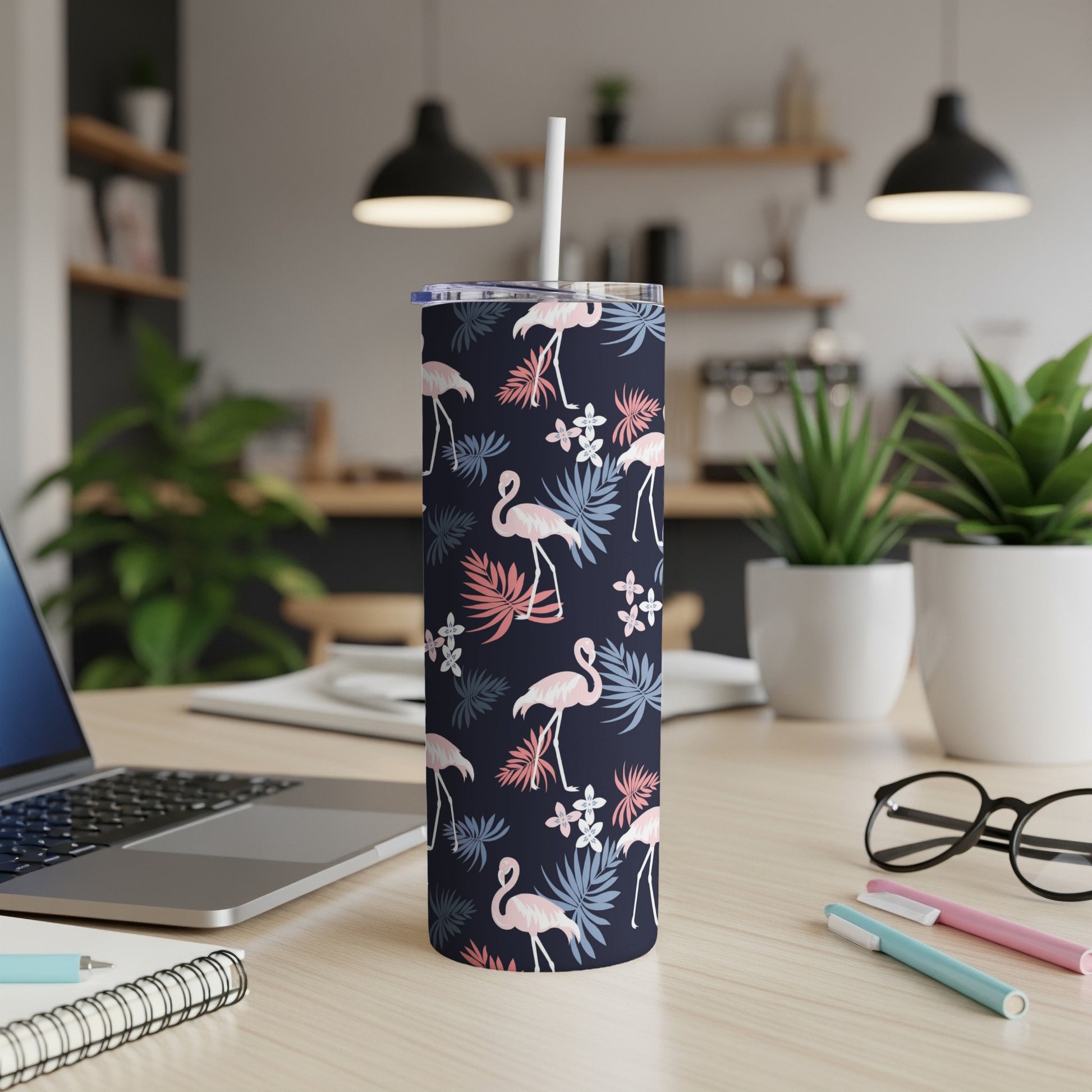 Dark blue tumbler with pink flamingos and palm leaves, straw inserted.