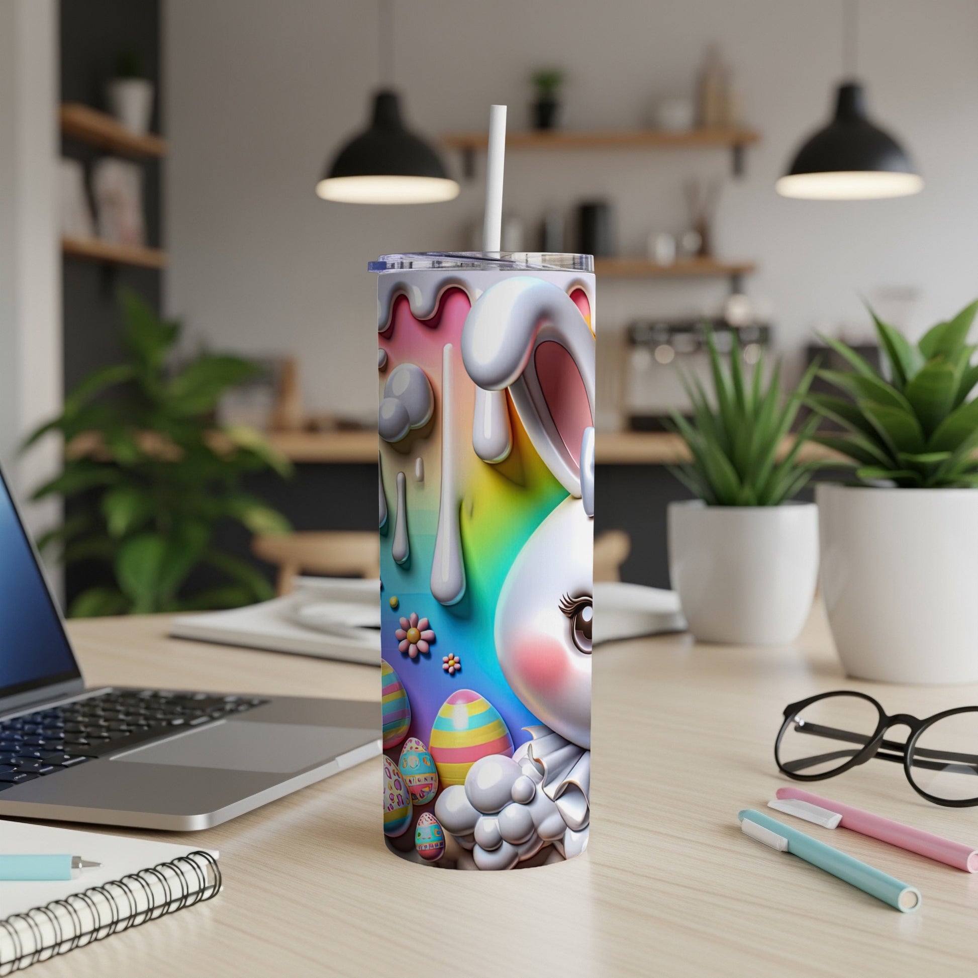 Easter bunny and eggs design on a tumbler with straw, laptop and pens on desk.