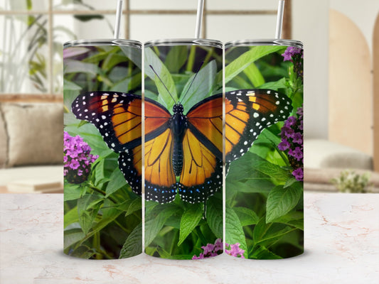 Monarch butterfly on green leaves with purple flowers, digitally rendered on a tumbler.