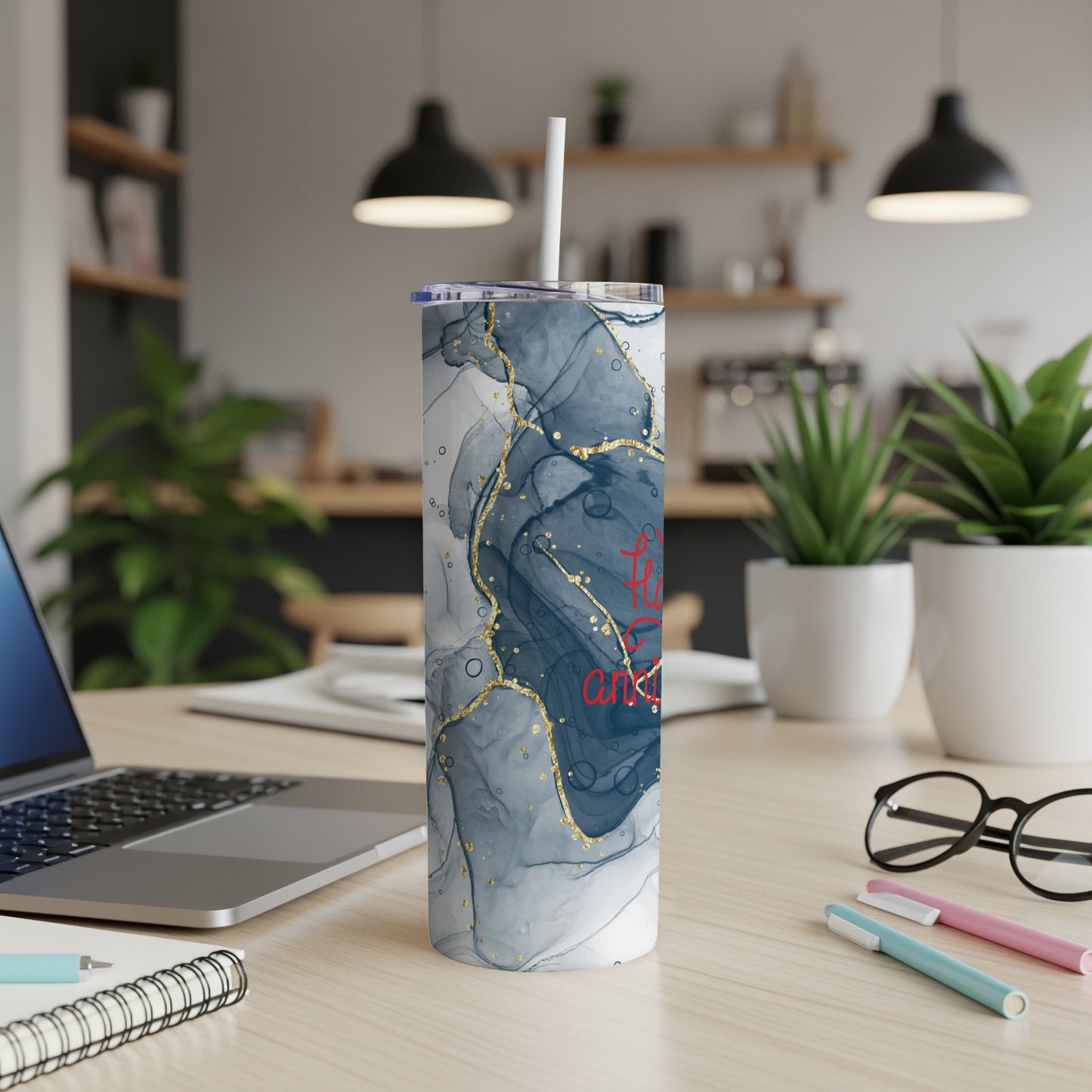 White tumbler with marbled blue and gold pattern and red text.
