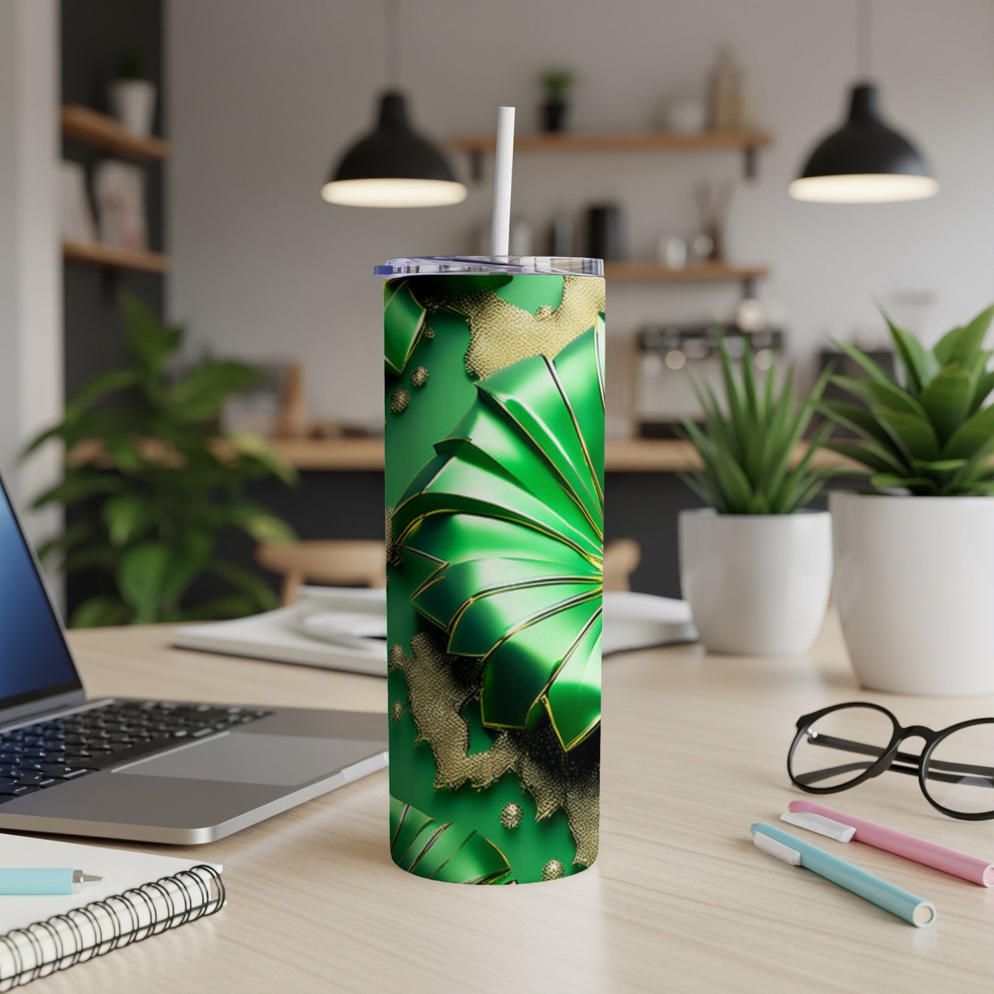 Green tumbler with gold accents and a straw, on a desk.