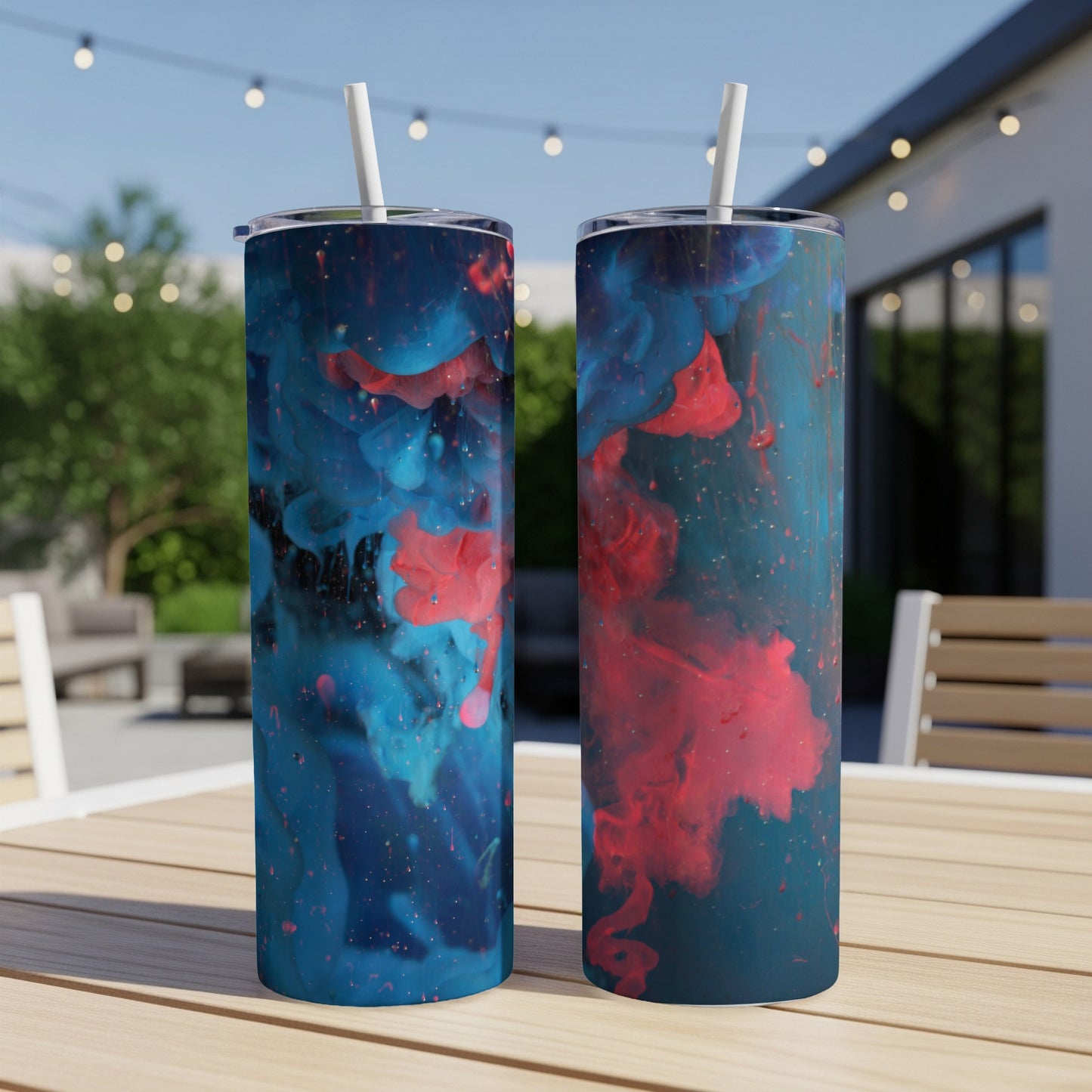 Two tumblers with blue and pink abstract ink designs on a wooden table.