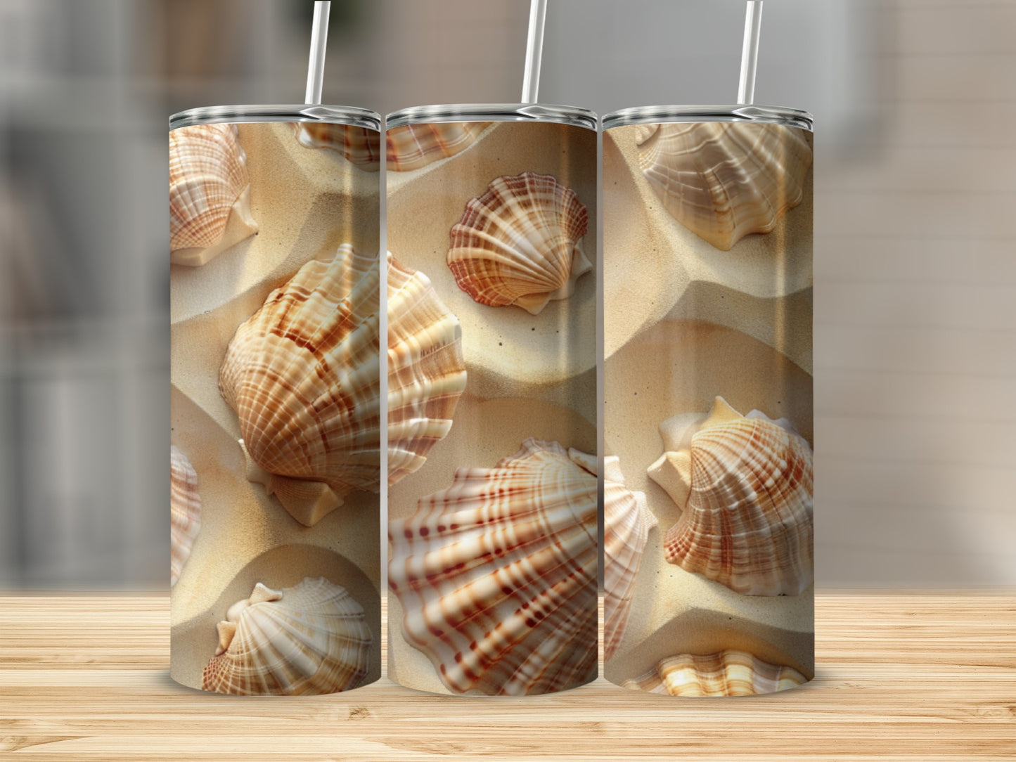 Three tumblers with seashell and sand pattern on wooden surface.