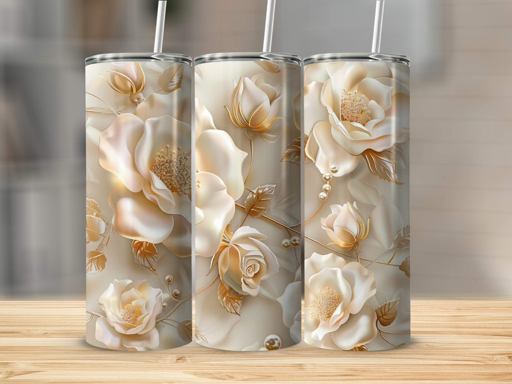 Three beige tumblers adorned with intricate cream and gold floral designs and pearls.