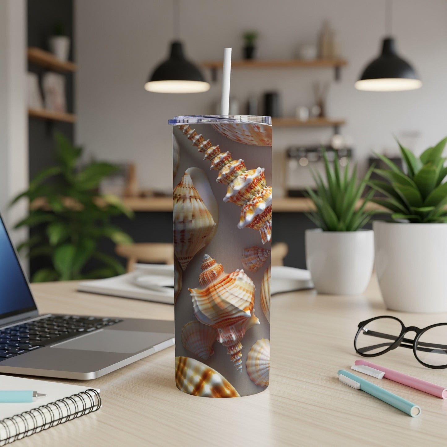 Seashell pattern on a stainless steel tumbler with a straw.