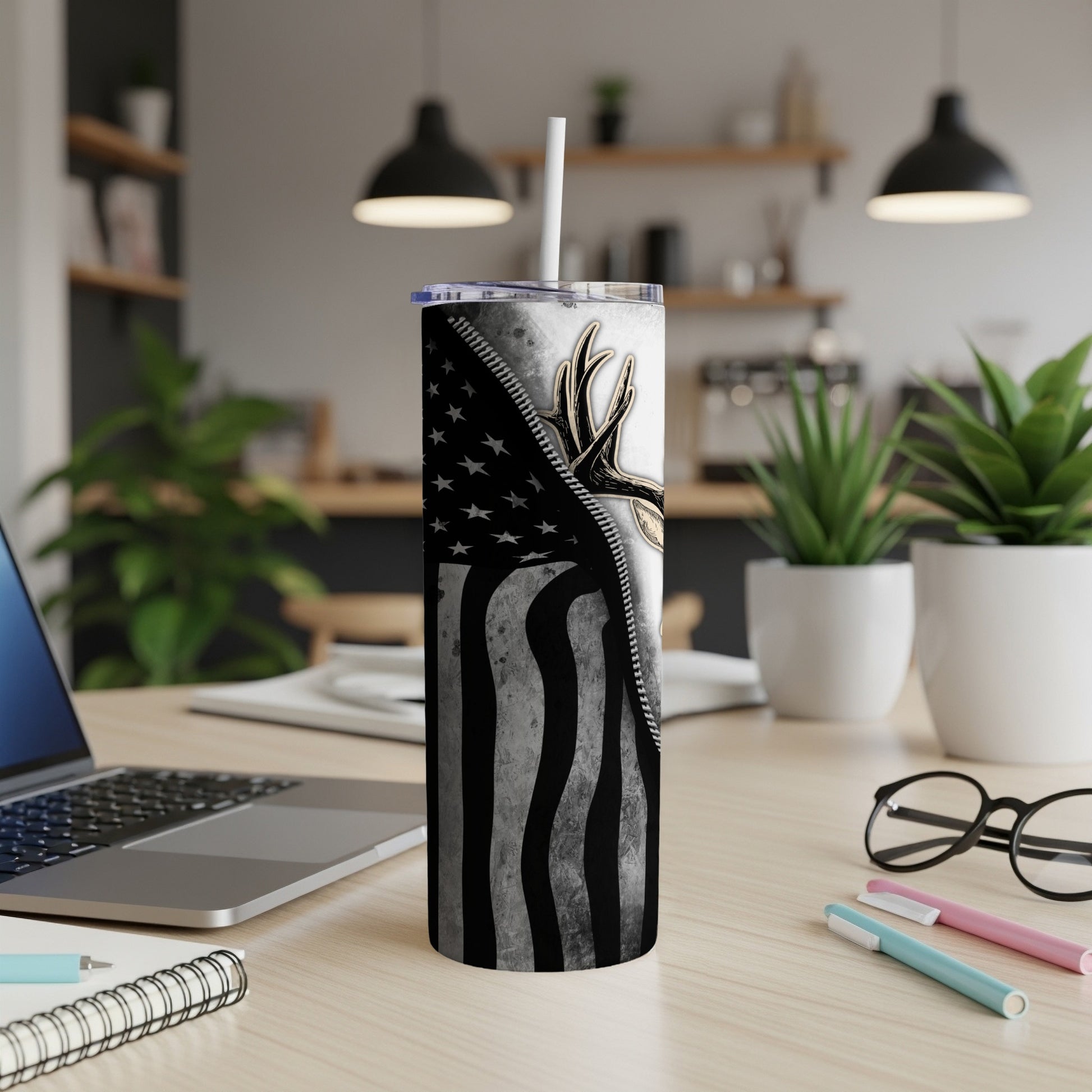 Tumbler with American flag design and deer antlers, with straw.