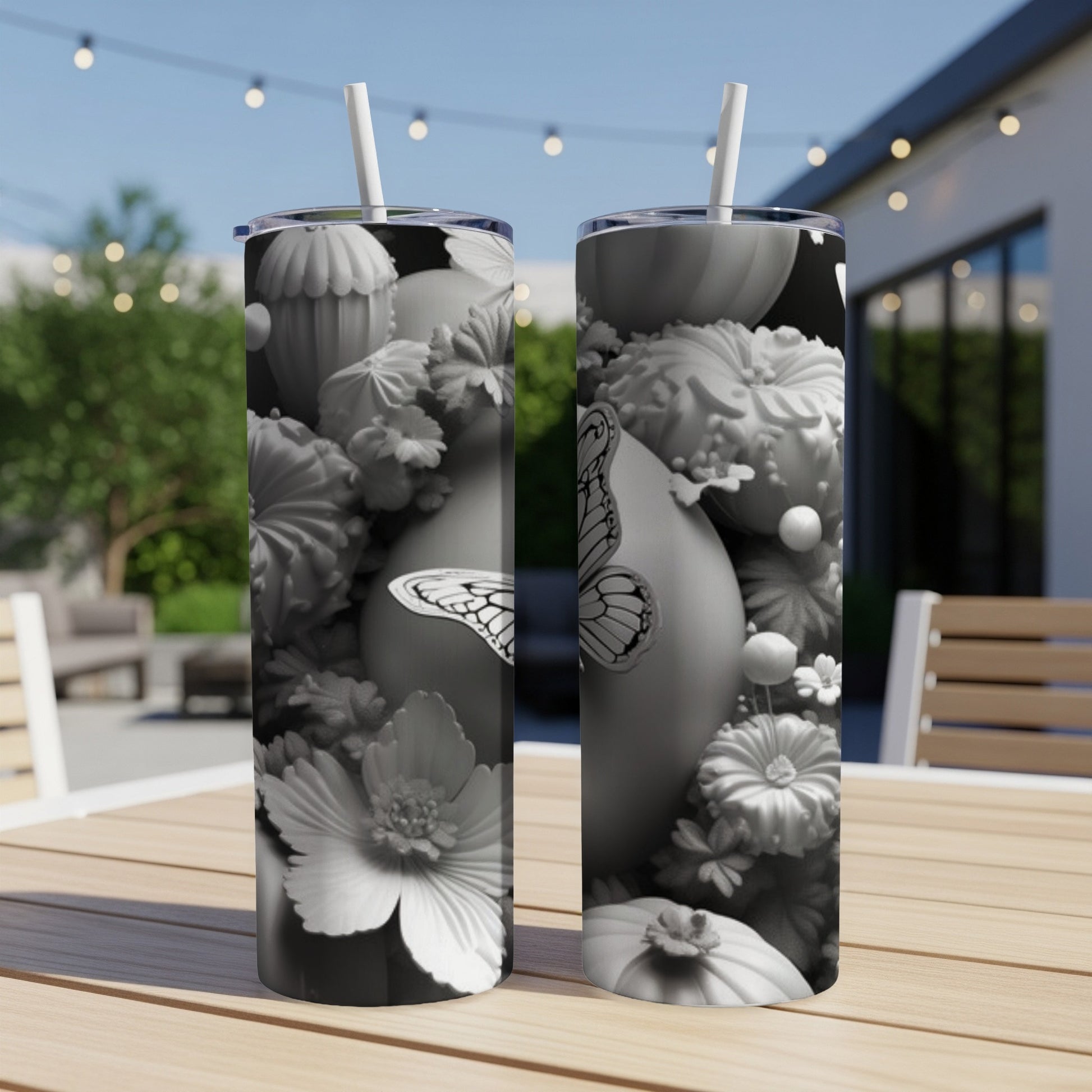 Black and white tumbler with floral and butterfly design on a table.
