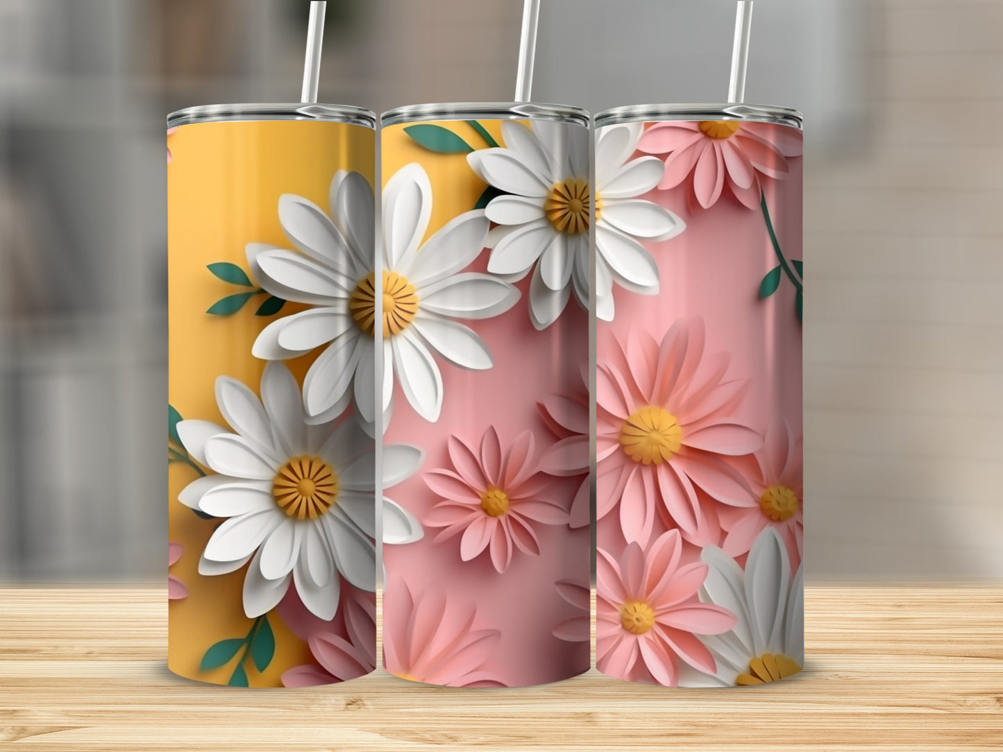 Three tumblers with floral daisy designs in yellow and pink.