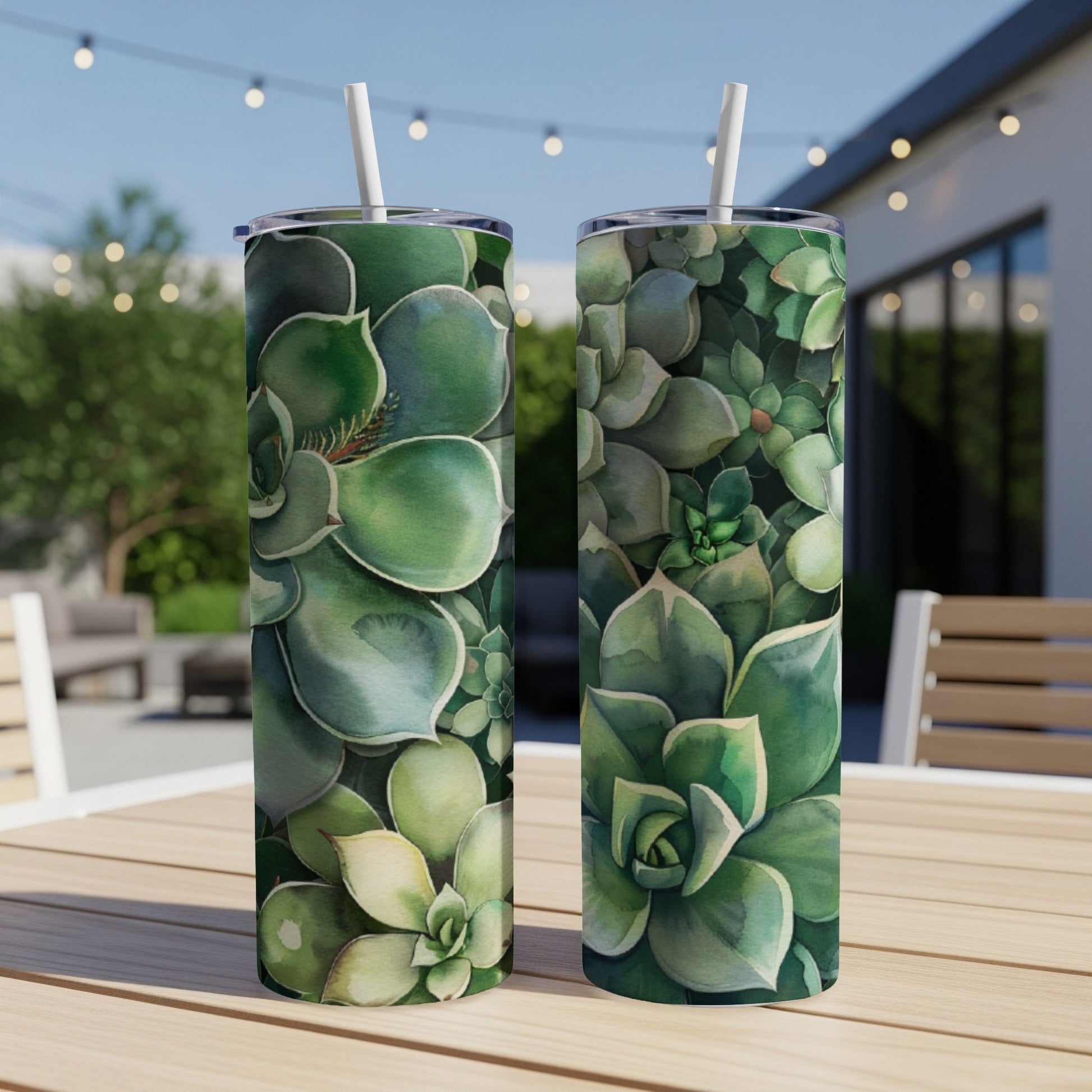 Two tumblers with watercolor green succulent patterns sit on a table.