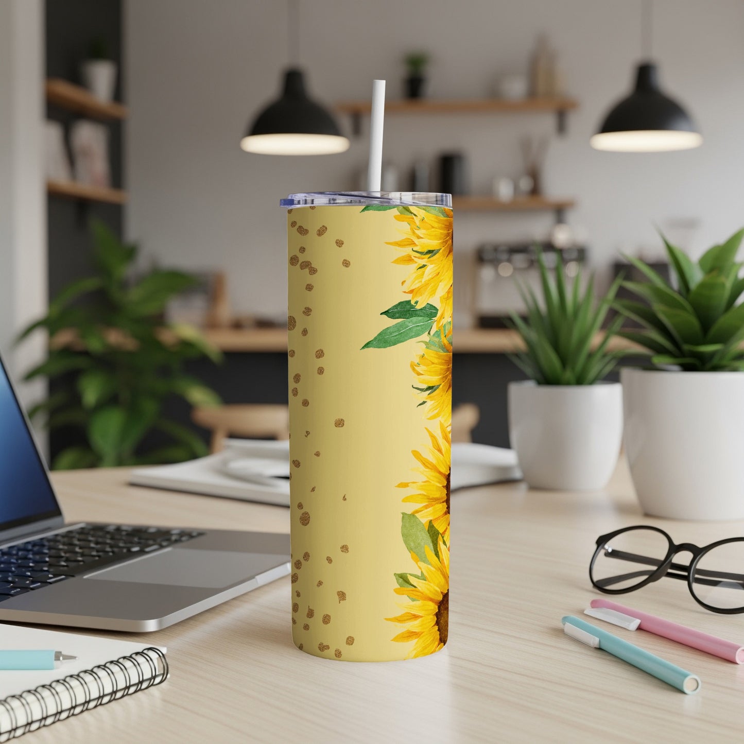 Yellow tumbler with sunflowers and gold polka dots, straw inserted.